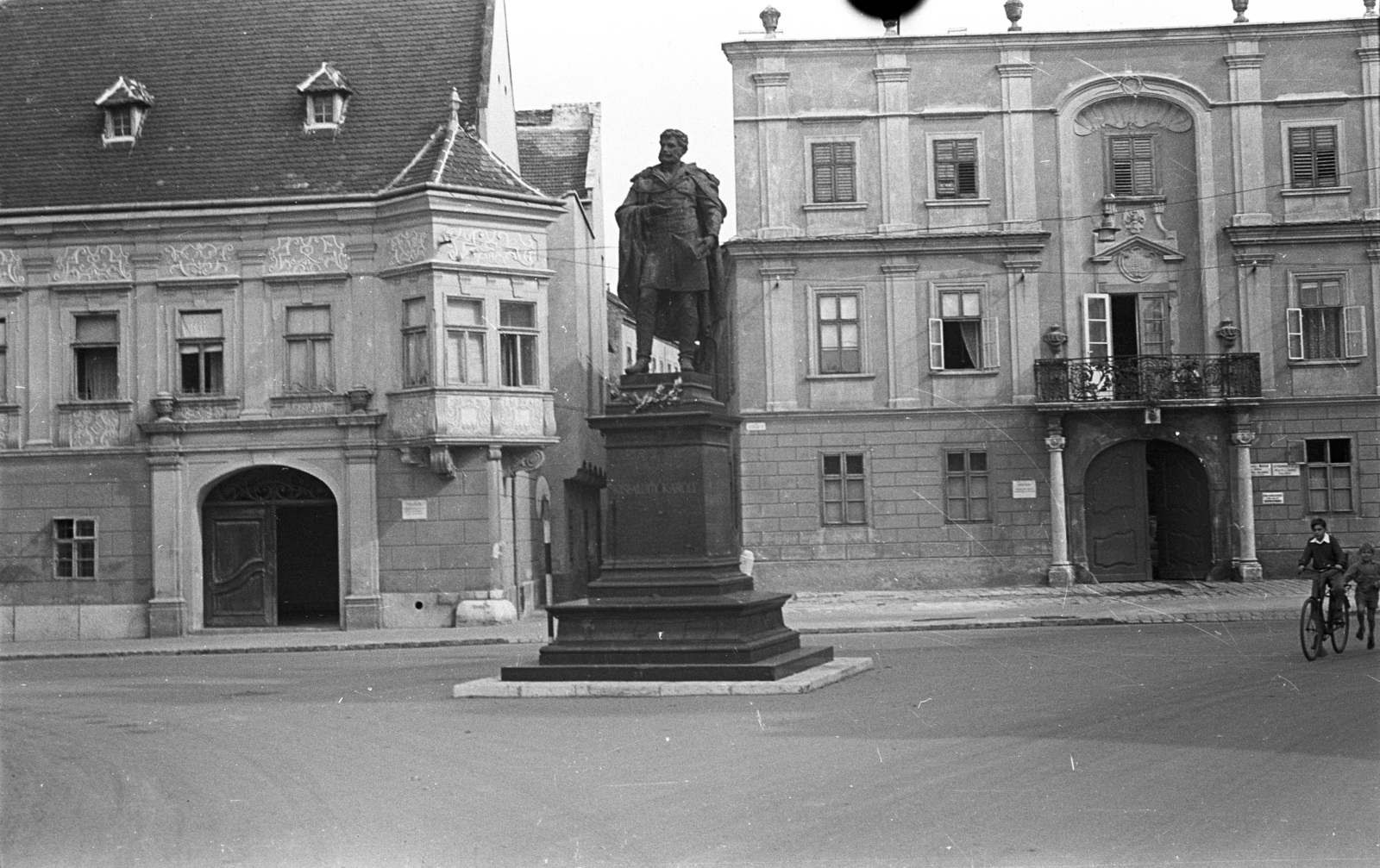 Magyarország, Győr, Bécsi kapu (Köztársaság) tér, Kisfaludy Károly szobor (Mátrai Lajos György, 1892.). Háttérben a Szabadsajtó utca torkolatánál az Altabak-ház és az Ott-ház., 1958, Lencse Zoltán, szobor, Kisfaludy Károly-ábrázolás, kerékpár, Fortepan #54586