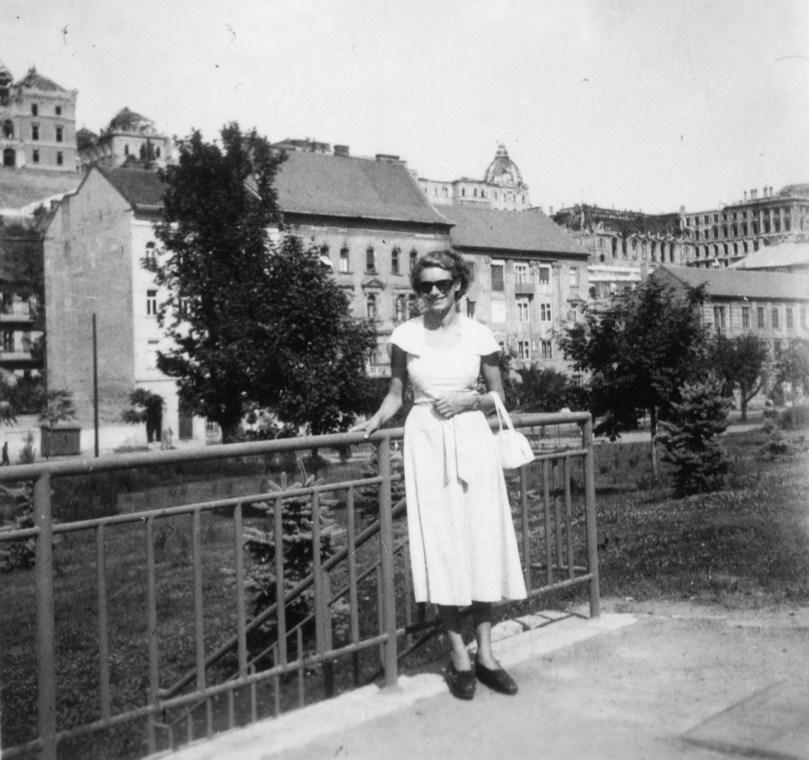 Hungary, Budapest I., háttérben az Attila út házai és a romos Királyi Palota (később Budavári Palota)., 1948, Magyar Bálint, portrait, railing, shades, handbag, lady, sandal, Budapest, summer dresses, Fortepan #55380