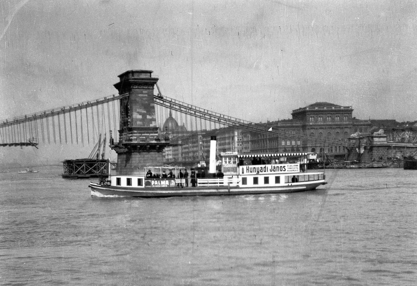 Hungary, Budapest V., a Széchenyi Lánchíd átépítése, a híd vasszerkezetének megerősítése a Dunáról nézve. Előtérben az Új-Pest csavargőzös., 1914, Magyar Bálint, ship, bridge building, steamboat, Budapest, suspension bridge, William Tierney Clark-design, Fortepan #55519