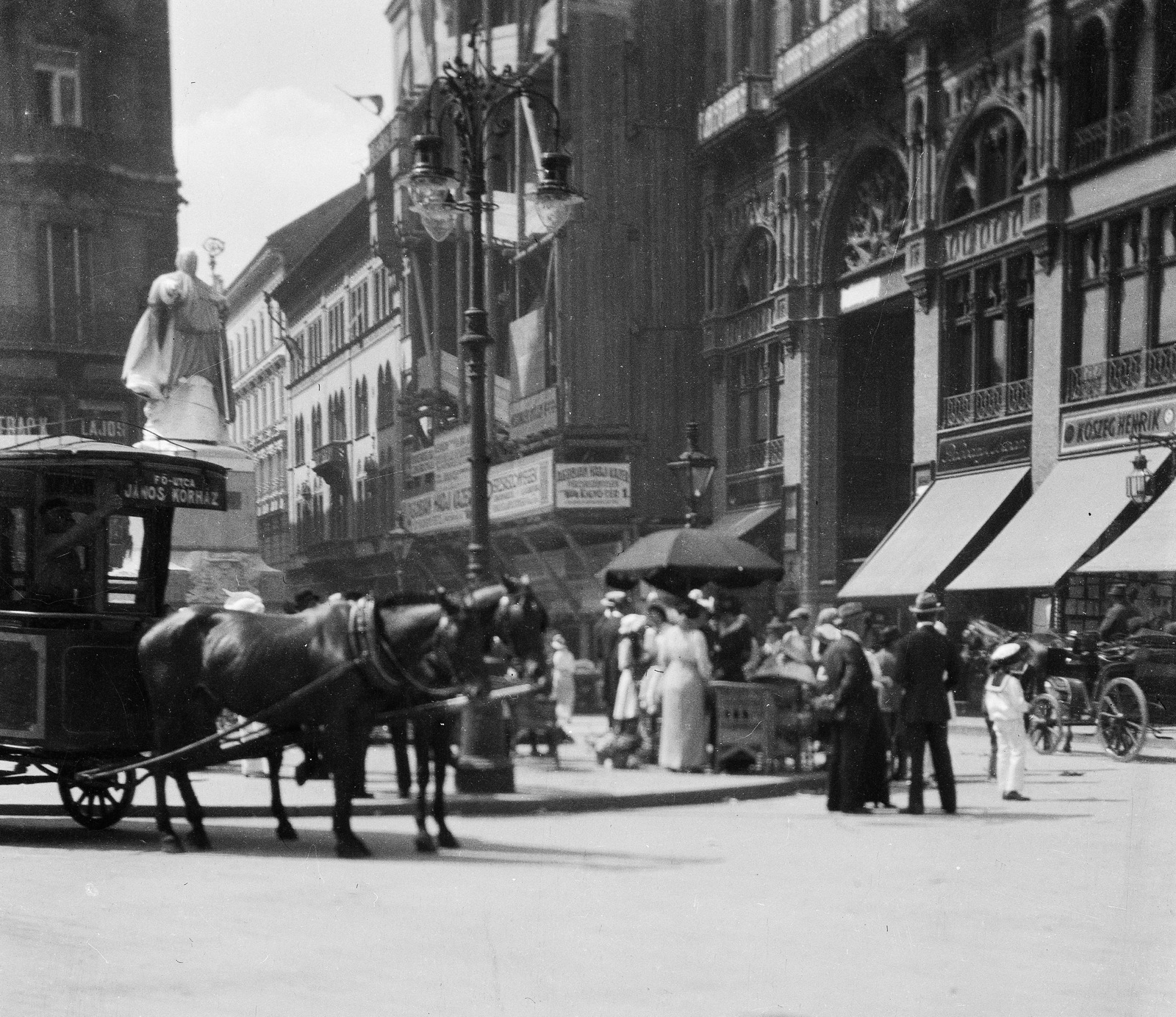 Magyarország, Budapest V., Ferenciek tere (Kígyó tér) Pázmány Péter szobrával. Jobbra a Girardi-ház építkezése., 1916, Magyar Bálint, reklám, szobor, utcakép, életkép, esernyő, lámpaoszlop, állvány, omnibusz, Pázmány Péter-ábrázolás, Budapest, Fortepan #55699