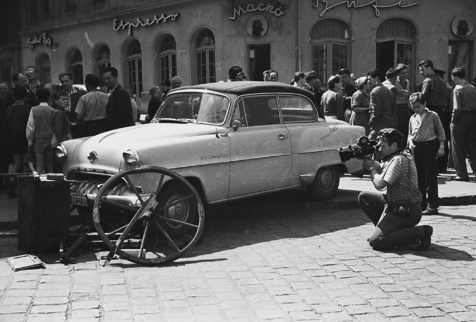 Hungary, Budapest I., Széna tér, Ostrom utca - Vérmező út sarok, az Opel Olympia típusú személygépkocsi előtt Mestyán Tibor az MTV operatőre térdel., 1960, Rádió és Televízió Újság, German brand, Opel-brand, accident, espresso, movie camera, cameraman, handbarrow, automobile, milk bar, Arriflex-brand, Budapest, Fortepan #56536