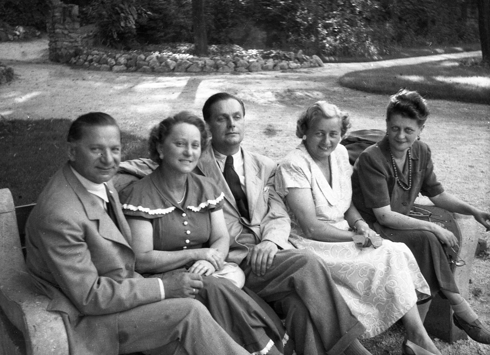 Hungary, Veszprém, Erzsébet liget, a felvétel a Veszprém Megyei Múzeum (később Laczkó Dezső Múzeum) előtt készült. Háttérben a Kálvária-dombra vezető lépcső kőkapuja., 1949, Karabélyos Péter, smile, tableau, lady, summer dresses, tie, suit, bench, Fortepan #57170