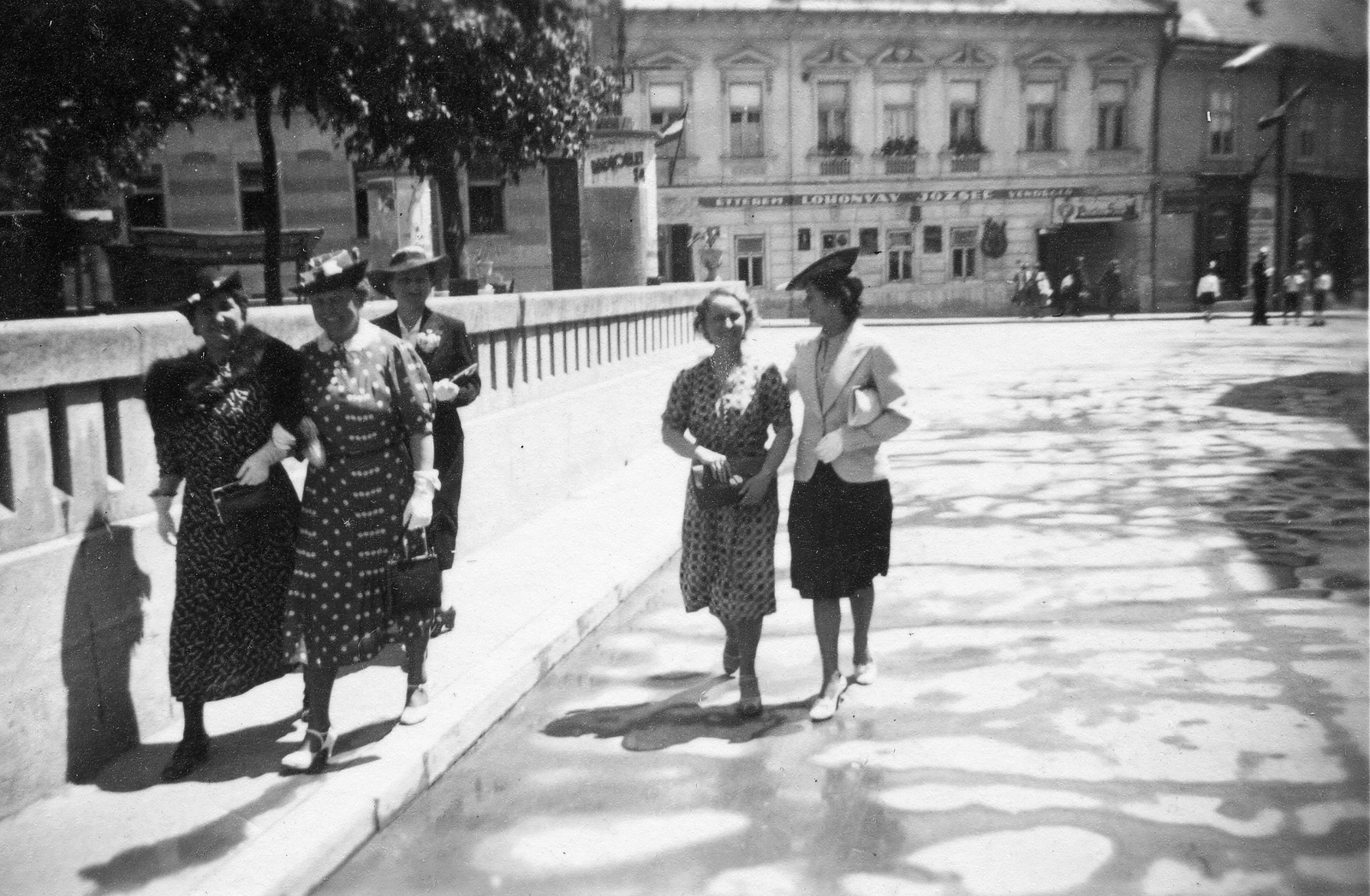 Magyarország, Veszprém, Óváros (Rákóczi) tér, háttérben jobbra a Rákóczi Ferenc utca torkolata látszik., 1935, Karabélyos Péter, divat, kalap, zászló, vendéglő, cégtábla, utcakép, életkép, hirdetőoszlop, elegancia, retikül, Fortepan #57441