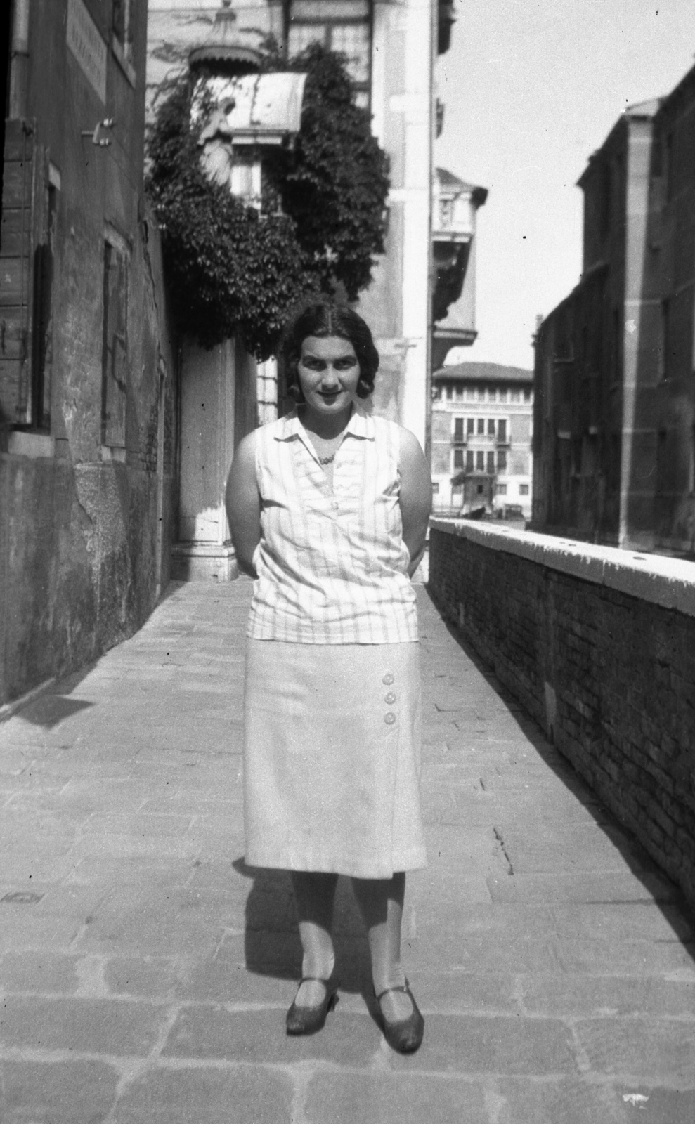 Olaszország, Velence, Fondamenta Razzonico a Canal Grande felé nézve, balra a Ca' Razzonico bejárata., 1935, Teodoro Wolf-Ferrari, portré, utcakép, nyaklánc, hölgy, szoknya, blúz, hátratett kéz, Fortepan #57668