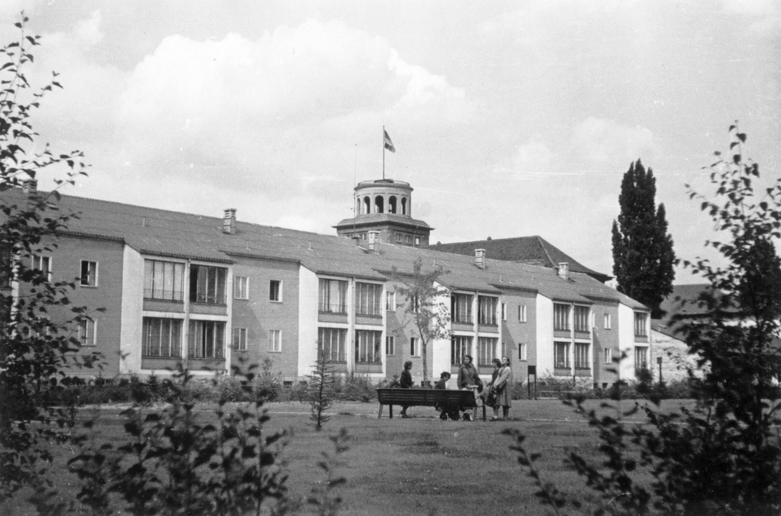 Germany, Berlin, a felvétel a Renatenweg környékén készült, háttérben az Ursulastraße és a Barbarastraße között az Auguste-Sprengel-Schule (ma Beethoven-Gymnasium) tornya látszik., 1942, Botár Angéla, building, bench, flag pole, Fortepan #57898