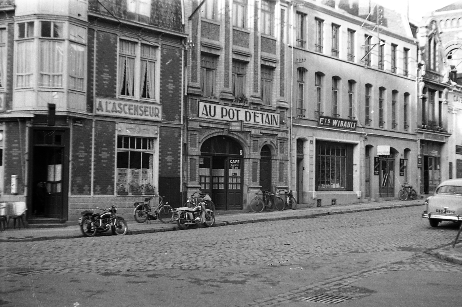 Franciaország, Cambrai, a Rue de la Citadelle a Rue des Frères Marsy felől nézve., 1957, Pierre Varga, motorkerékpár, üzletportál, francia felirat, Fortepan #57958