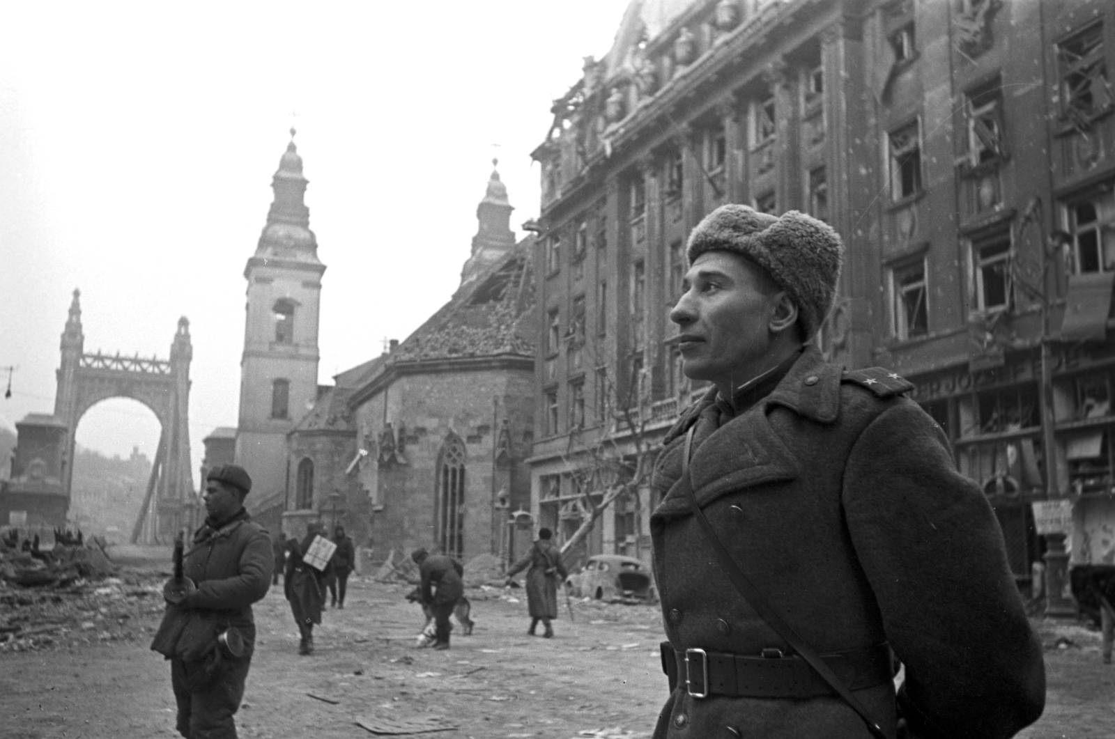 Magyarország, Budapest V., Szabad sajtó (Eskü) út az Erzsébet híd felé nézve, jobbra a Belvárosi templom és a Piarista Gimnázium. Lebigy Nyikolaj Szergejevics szovjet alezredes., 1945, Fortepan, kutya, járműroncs, katona, szovjet katona, gépfegyver, PPS géppisztoly, Budapest, függőhíd, szőrmesapka, Kherndl Antal-terv, Czekelius Aurél-terv, Fortepan #58307