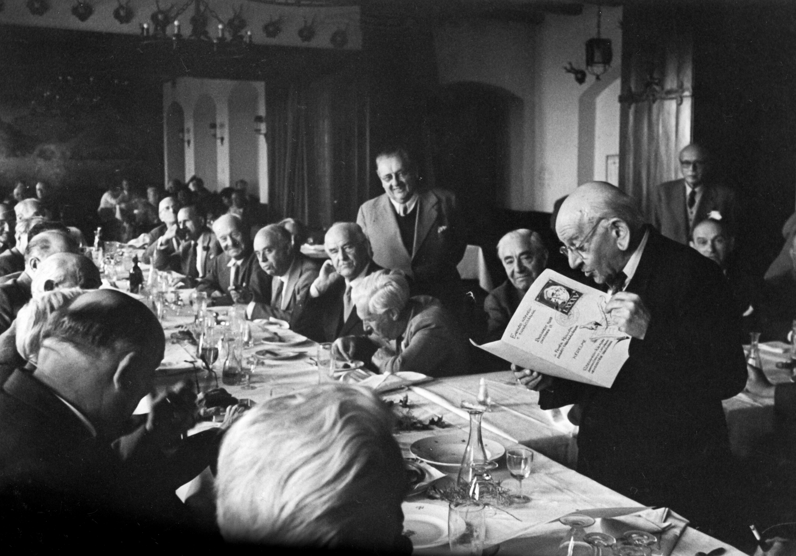 Magyarország, Budapest VII., Fészek Klub. A felvétel a Fehér Hollók Baráti Társaság ünnepi összejövetelén, Rózsahegyi Kálmán 85. születésnapján készült., 1958, Németh Tamás, Urai Dezső, vendéglátás, vendéglő, enteriőr, trófea, csillár, teríték, pohár, szónok, társaság, borkínáló üveg, karaf, Budapest, Fortepan #59321