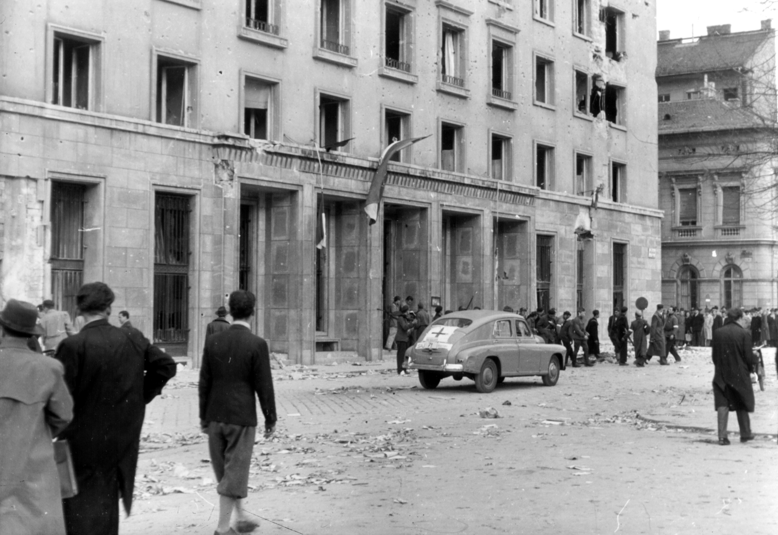 Magyarország, Budapest VIII., II. János Pál pápa (Köztársaság) tér 26., a Budapesti Pártbizottság székháza., 1956, Fortepan, háborús kár, szovjet gyártmány, GAZ-márka, pártház, felkelő, forradalom, bricsesz, épületkár, vöröskereszt, karszalag, automobil, GAZ M20 Pobeda, Budapest, Államvédelmi Hatóság, Fortepan #6402
