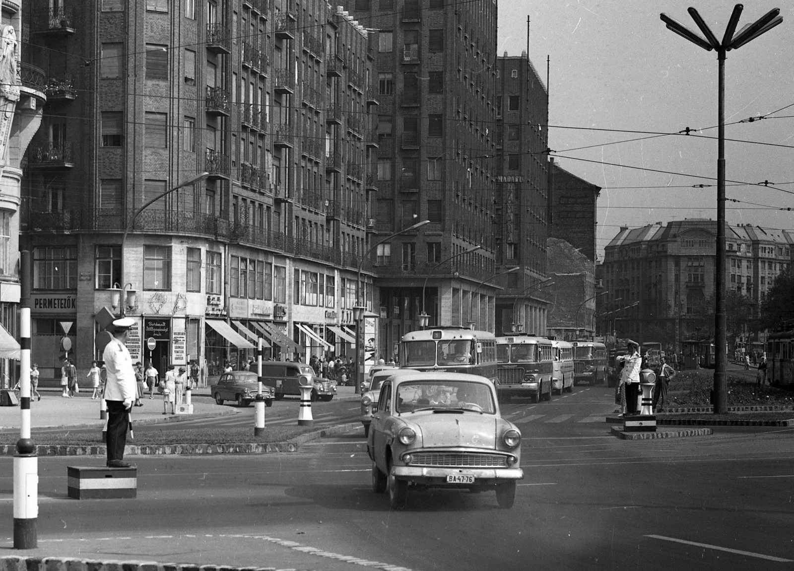 Magyarország, Budapest V.,Budapest VII., Deák Ferenc tér, a Károly (Tanács) körút a Dohány utca felé nézve., 1964, Magyar Rendőr, autóbusz, járókelő, utcakép, életkép, Ikarus-márka, rendőr, hirdetőoszlop, csibilámpa, dobogó, Ikarus 620/630, Skoda Octavia, Moszkvics 407, rendszám, Framo-márka, furgon, rendőrdobogó, Budapest, Fortepan #65067