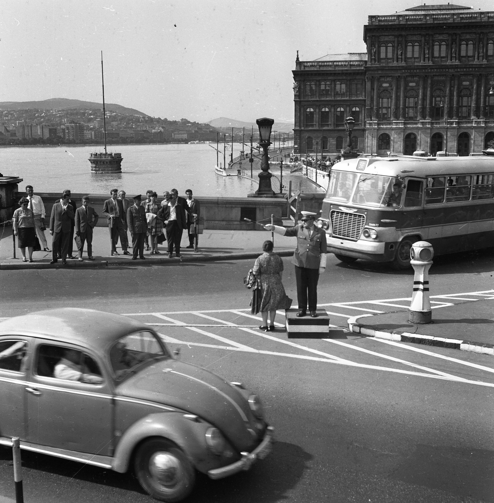 Hungary, Budapest V., Széchenyi Lánchíd pesti hídfője, jobbra a Magyar Tudományos Akadémia épülete. A felvétel az 1965-ös árvíz idején készült., 1965, Magyar Rendőr, bus, German brand, Hungarian brand, Volkswagen-brand, flood, Renaissance Revival, Ikarus 620, Volkswagen Beetle, pulpit for police officers, Hungarian Academy of Sciences, Budapest, Friedrich August Stüler-design, directing traffic, Fortepan #65149