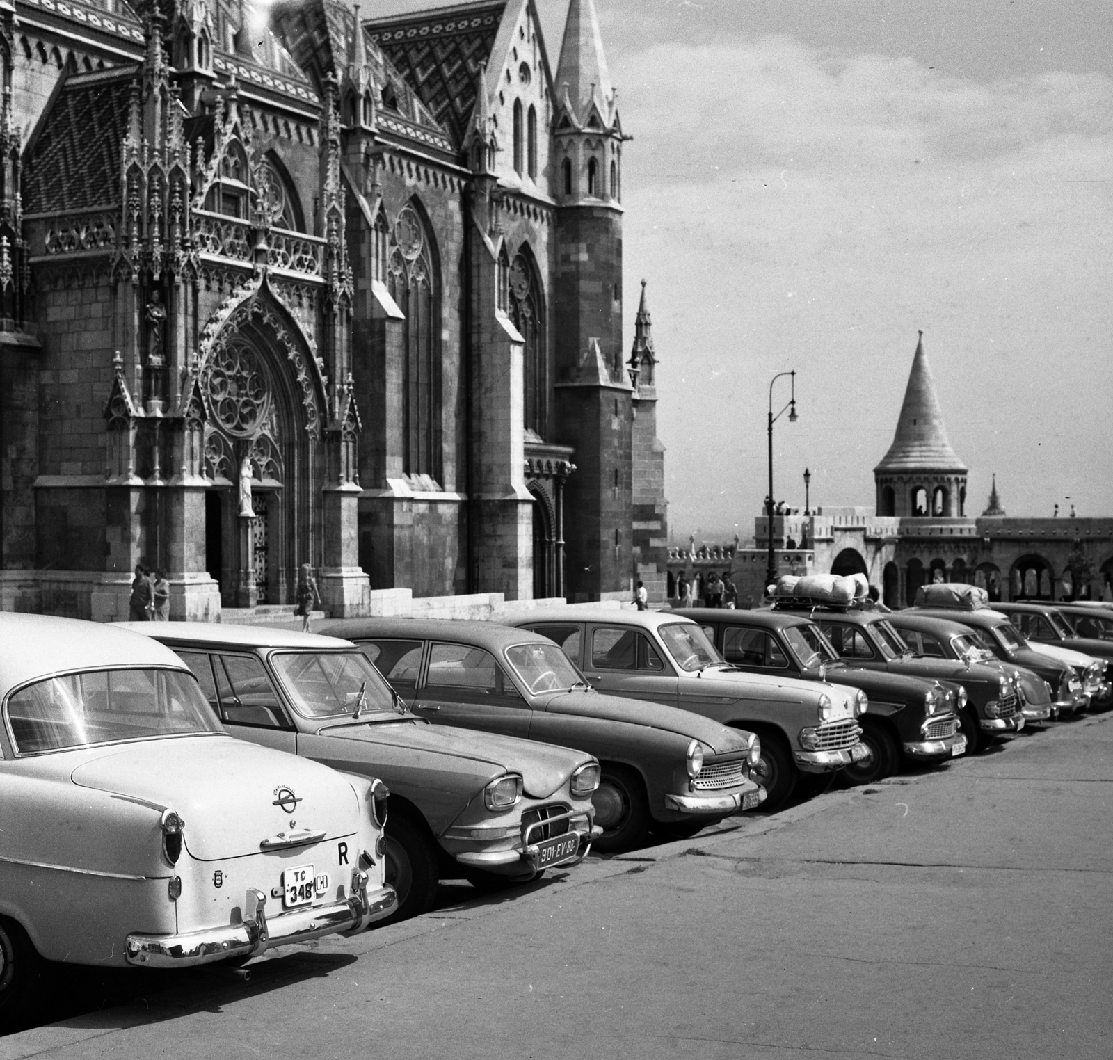 Hungary, Budapest I., Szentháromság tér, balra a Mátyás-templom, jobbra a Halászbástya., 1965, Magyar Rendőr, German brand, Opel-brand, Renault-brand, Moskvitch-brand, Wartburg-brand, automobile, number plate, tracery, Budapest, roof rack, diplomatic sign, country code sign, Fortepan #65182