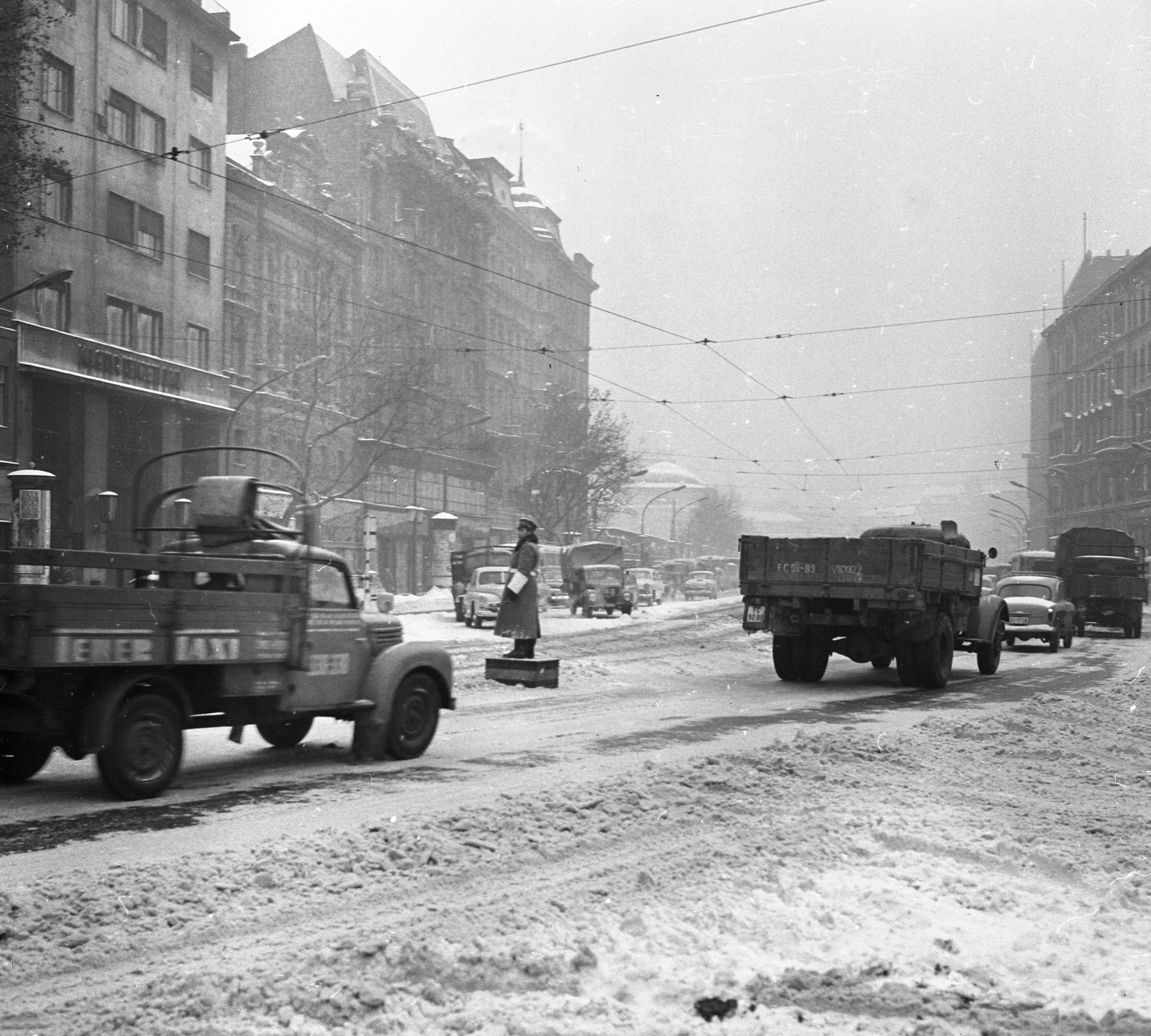 Hungary, Budapest V.,Budapest VII., Károly (Tanács) körút a Deák Ferenc tér felé nézve., 1965, Magyar Rendőr, winter, snow, traffic, commercial vehicle, street view, cop, number plate, pulpit for police officers, catenary wire, u-haul, Budapest, Fortepan #65260