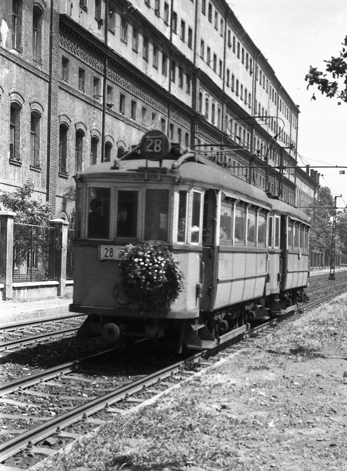 Hungary, Budapest VIII., Kőbányai út, háttérben Könyves Kálmán körút sarok. Balra a Kőbányai Dohánygyár, bezárás után átalakított épülete, majd a Beloiannisz falu felépüléséig görög kolónia., 1966, Magyar Rendőr, tram, wreath, Budapest, public transport line number, Fortepan #65349