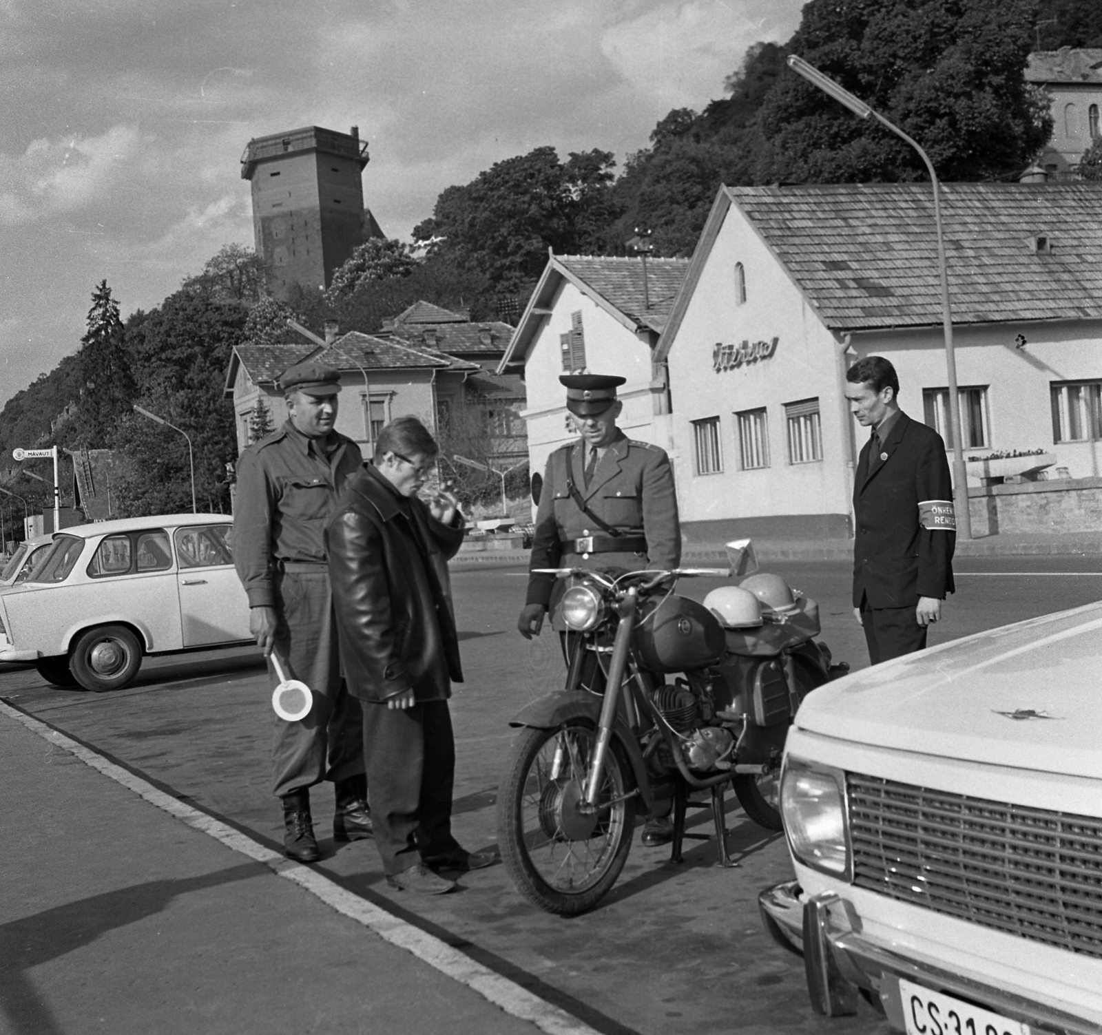 Hungary,Danube Bend, Visegrád, közúti ellenörzés a 11- es főúton a hajóállomás közelében. Szemben az Alsóvár lakótornya / Salamon-torony., 1968, Magyar Rendőr, Trabant-brand, Wartburg-brand, peaked cap, crash helmet, boots, volunteer police, directing traffic, signalling disc, Fortepan #65667