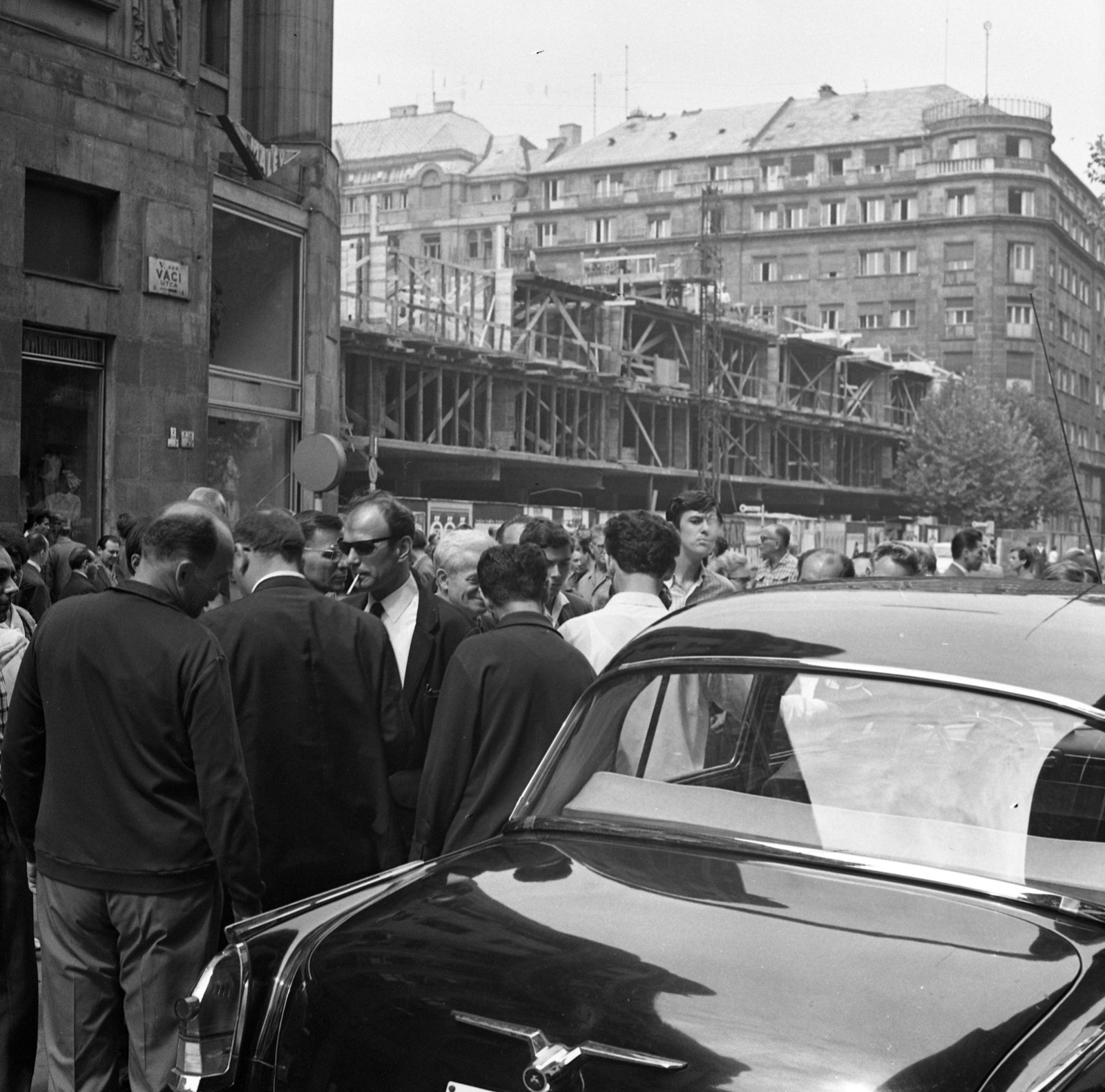 Magyarország, Budapest V., a Vörösmarty téri épülő ORI (Országos Rendező Iroda) székháza a Váci utcából nézve., 1968, Magyar Rendőr, cigaretta, dohányzás, építkezés, napszemüveg, csoportosulás, Budapest, Fortepan #65727