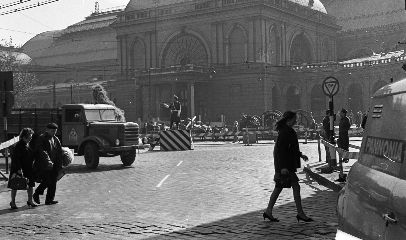 Hungary, Budapest VIII.,Budapest VII., Baross tér, a Keleti pályaudvar indulási oldala a Nefelejcs utcából nézve., 1968, Magyar Rendőr, commercial vehicle, cop, cobblestones, train station, road sign, pulpit for police officers, eclectic architecture, Budapest, Gyula Rochlitz-design, directing traffic, Fortepan #65753