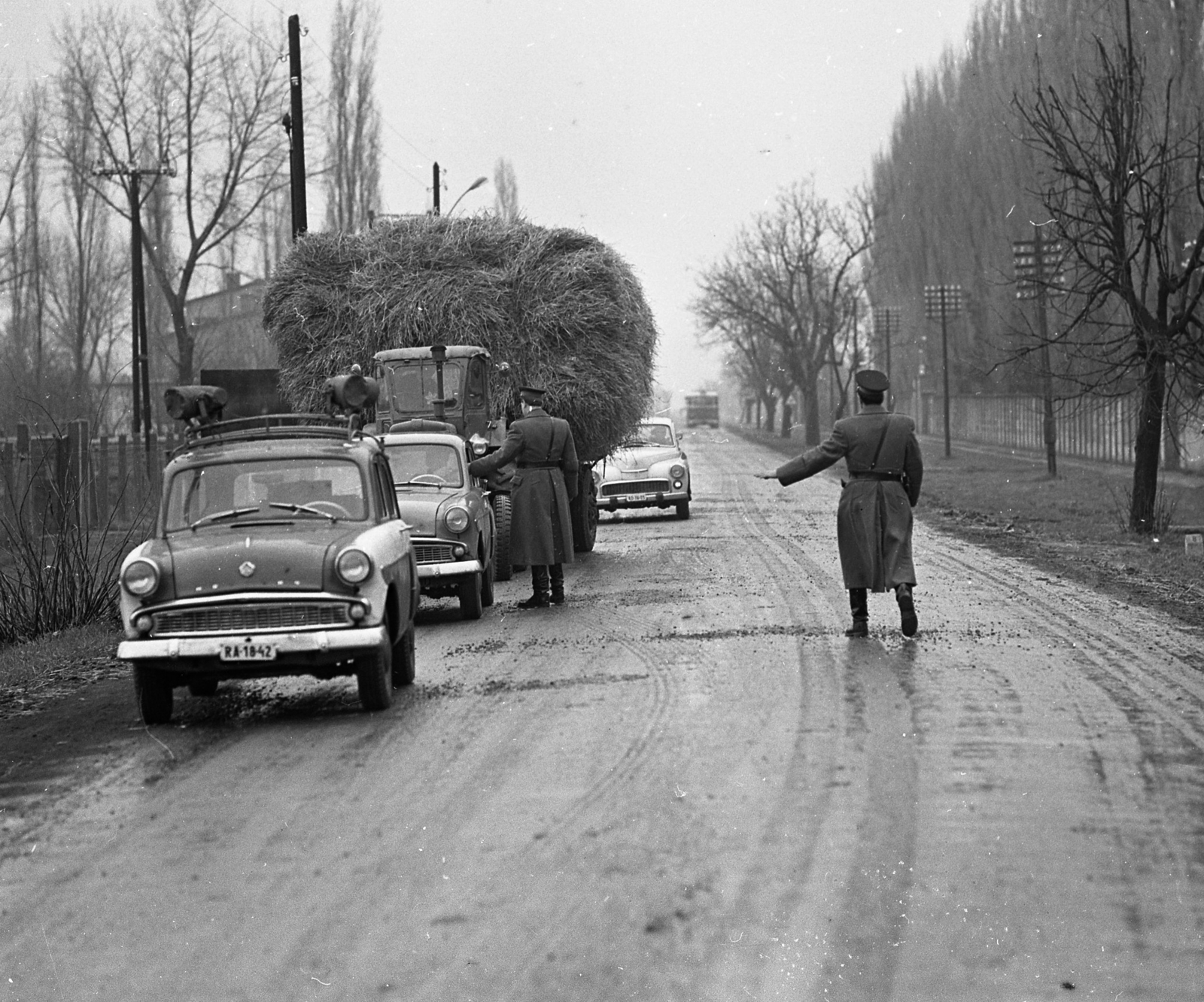 Hungary, Berettyóújfalu, Honvéd utca, igazoltatás a 47-es főúton, jobbra a laktanya kerítése látható., 1969, Magyar Rendőr, police vehicle, hay, Moskvitch-brand, cop, number plate, Fortepan #65777
