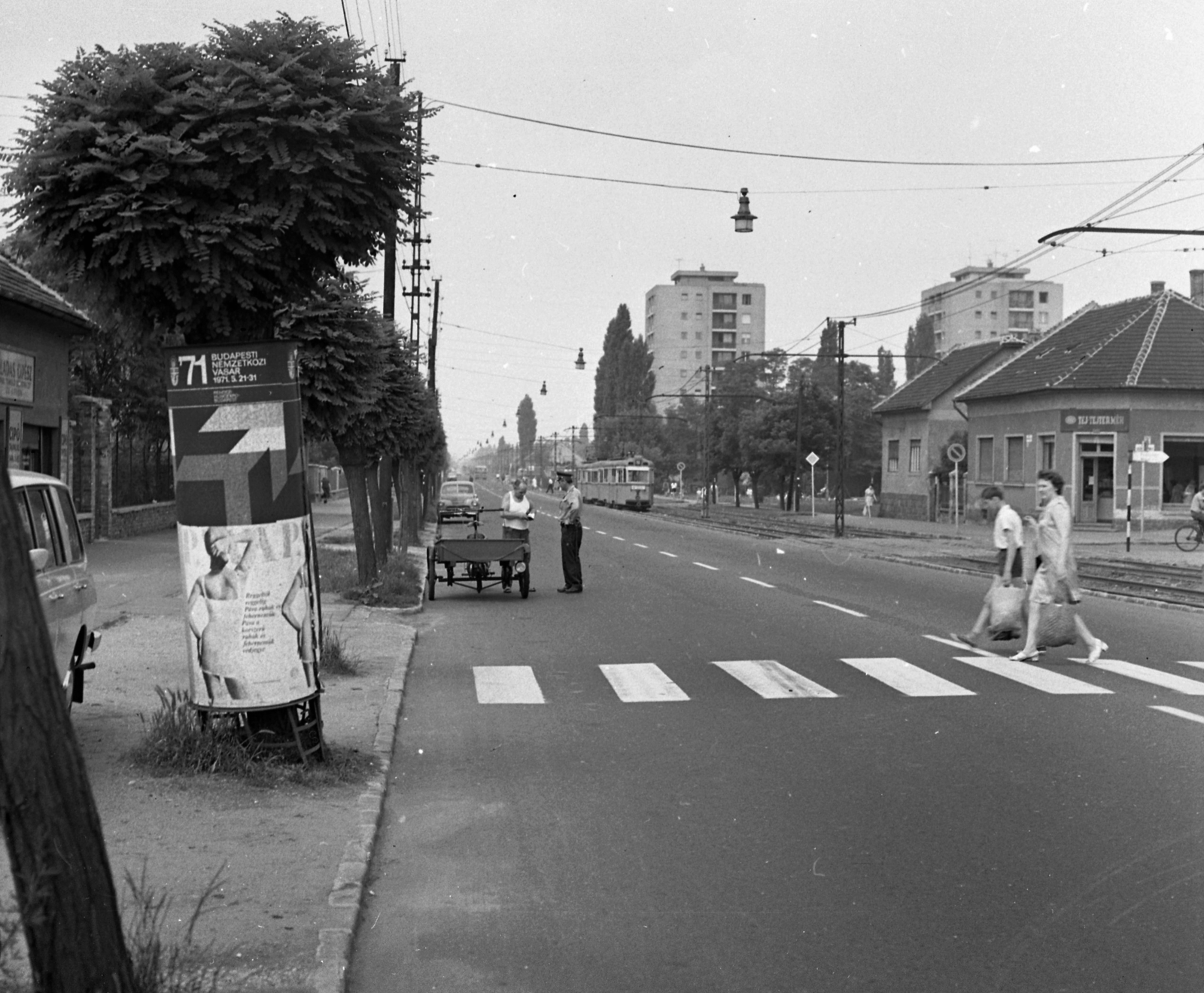 Magyarország, Budapest XVIII., Üllői út (Vörös Hadsereg útja), jobbra a Széchenyi István utca torkolata, háttérben a Lakatos úti lakótelep toronyházai., 1971, Magyar Rendőr, Budapest, rendőr, villamos, hirdetőoszlop, gyalogátkelő, Fortepan #65838