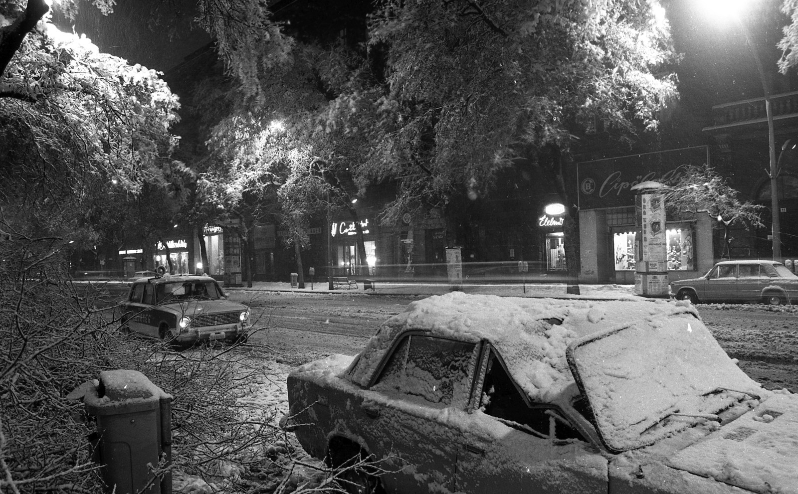 Hungary, Budapest VI., Andrássy út (Népköztársaság útja), szemben a 13. számú ház., 1980, Magyar Rendőr, winter, snow, ad pillar, wreck, trash can, police vehicle, Budapest, vehicular beacon, Fortepan #66520