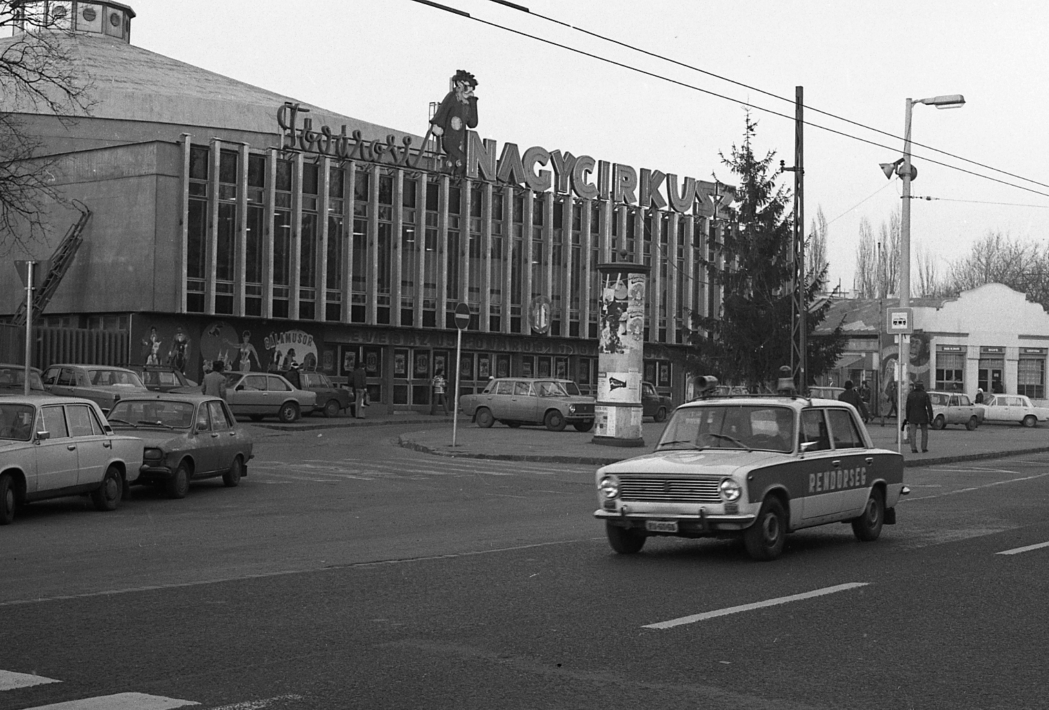 Magyarország, Városliget, Budapest XIV., Állatkerti körút, Fővárosi Nagycirkusz., 1981, Magyar Rendőr, plakát, járda, járókelő, hirdetőoszlop, buszmegálló, parkoló, épület, hangszóró, jelzőtábla, cirkusz, Dacia 1300, rendőrjármű, VAZ 2101, neon felirat, Budapest, ostorlámpa, Opel Rekord E, Fortepan #66541