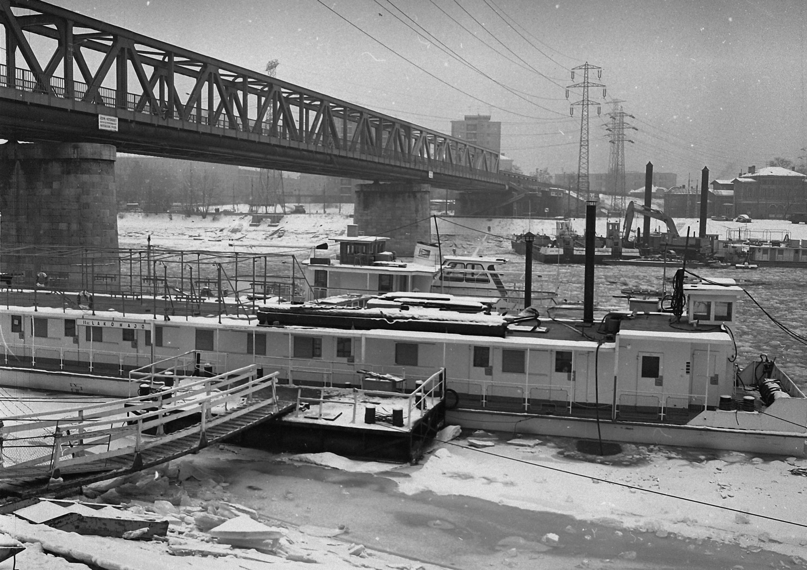 Magyarország, Budapest XIII.,Budapest IV., Újpesti-öböl, az Újpesti vasúti híd a Népszigetről a pesti hídfő felé nézve., 1982, Magyar Rendőr, hajó, tél, híd, kikötő, jégzajlás, távvezeték, ponton, Budapest, Március 15. hajó, Fortepan #66796