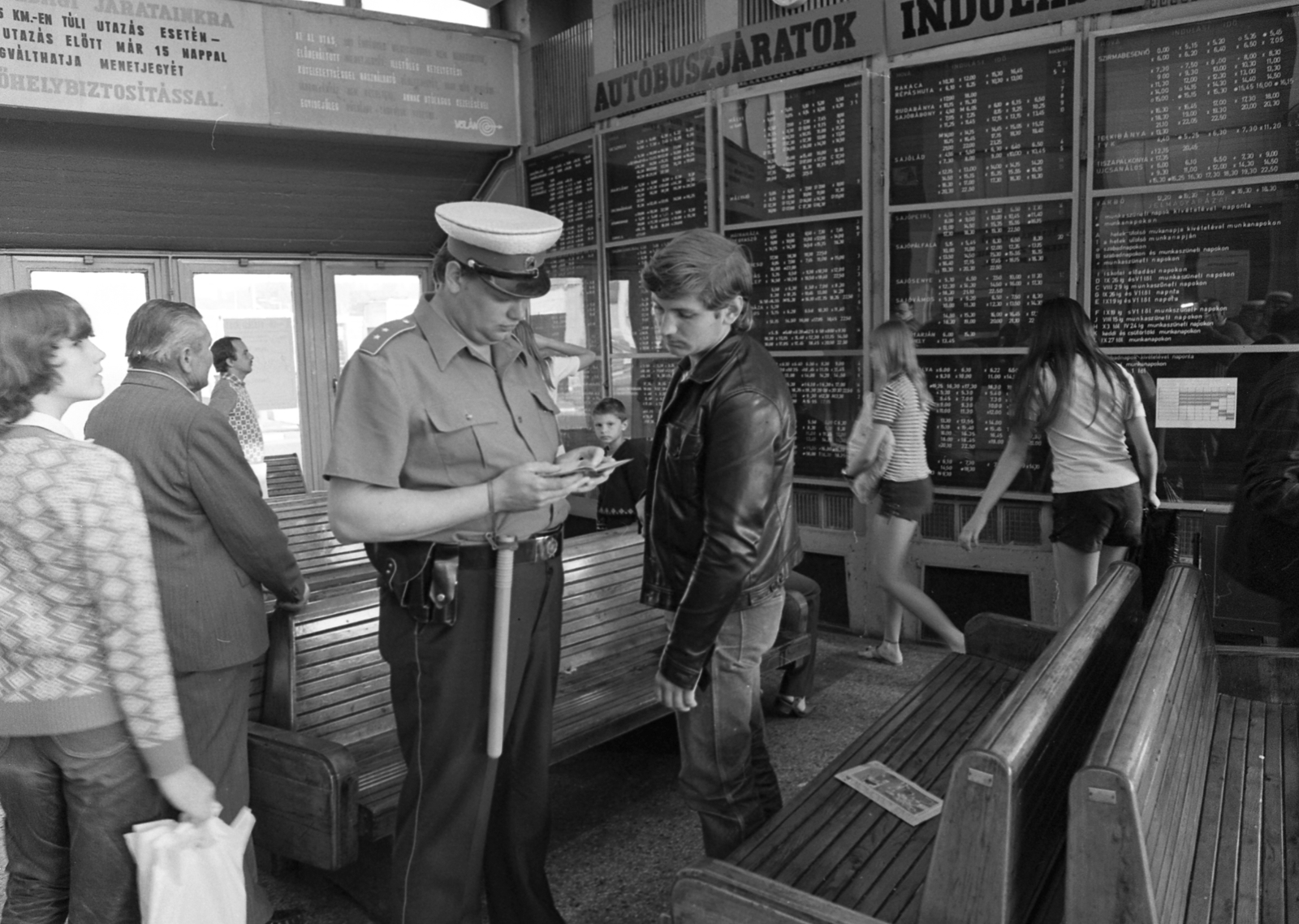 Hungary, Miskolc, Búza tér, az autóbusz-állomás váróterme., 1982, Magyar Rendőr, cop, identity check, bus stop, kid, man, newspaper, boys, schedule, waiting room, bench, girls, Fortepan #66838