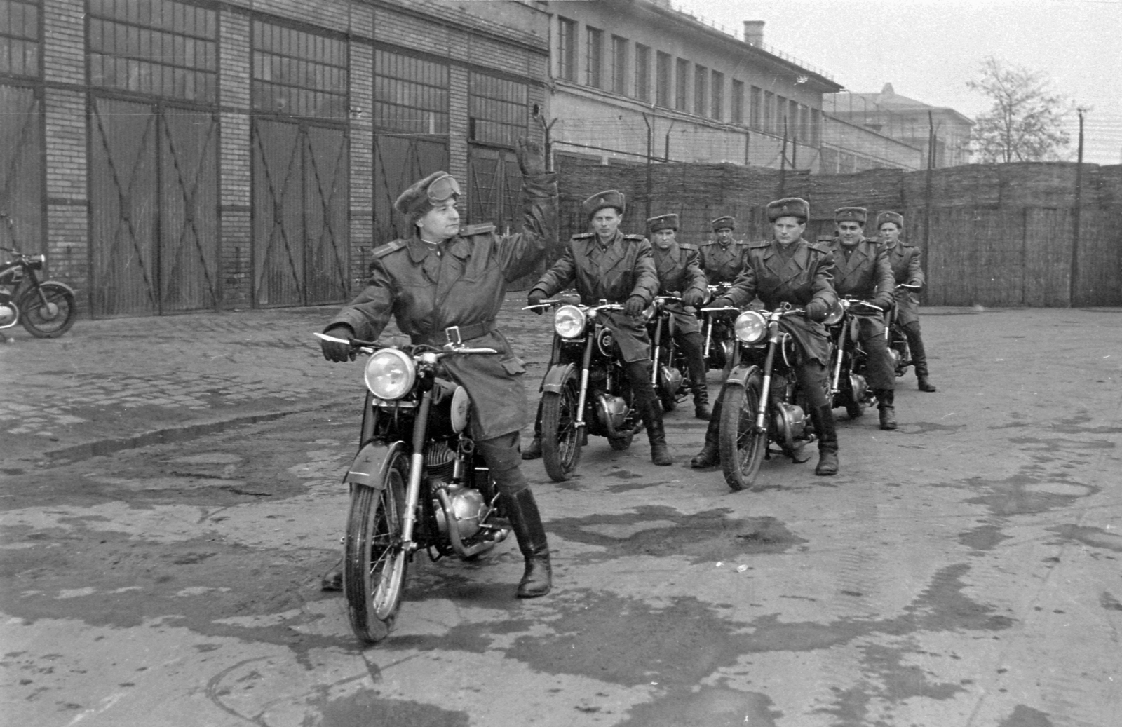 Magyarország, Budapest VIII., Mosonyi utcai rendőrség udvara és garázsai a Lóvásár utca írányába nézve., 1956, Magyar Rendőr, rendőr, gesztus, Csepel 250, Budapest, motoros rendőr, szőrmesapka, Fortepan #67278