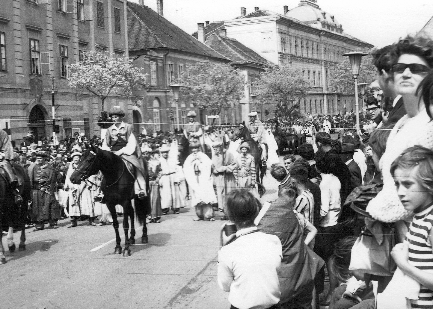 Hungary, Szombathely, Szily János (Alkotmány) utca, a Savaria Történelmi Karnevál résztvevőinek felvonulása a Mindszenty József (Templom) tér közelében. Jobbra a háttérben a Szombathelyi Törvényszék épülete., 1967, Kelemen Zoltán, street view, march, costume, audience, lamp post, rider, Fortepan #69946
