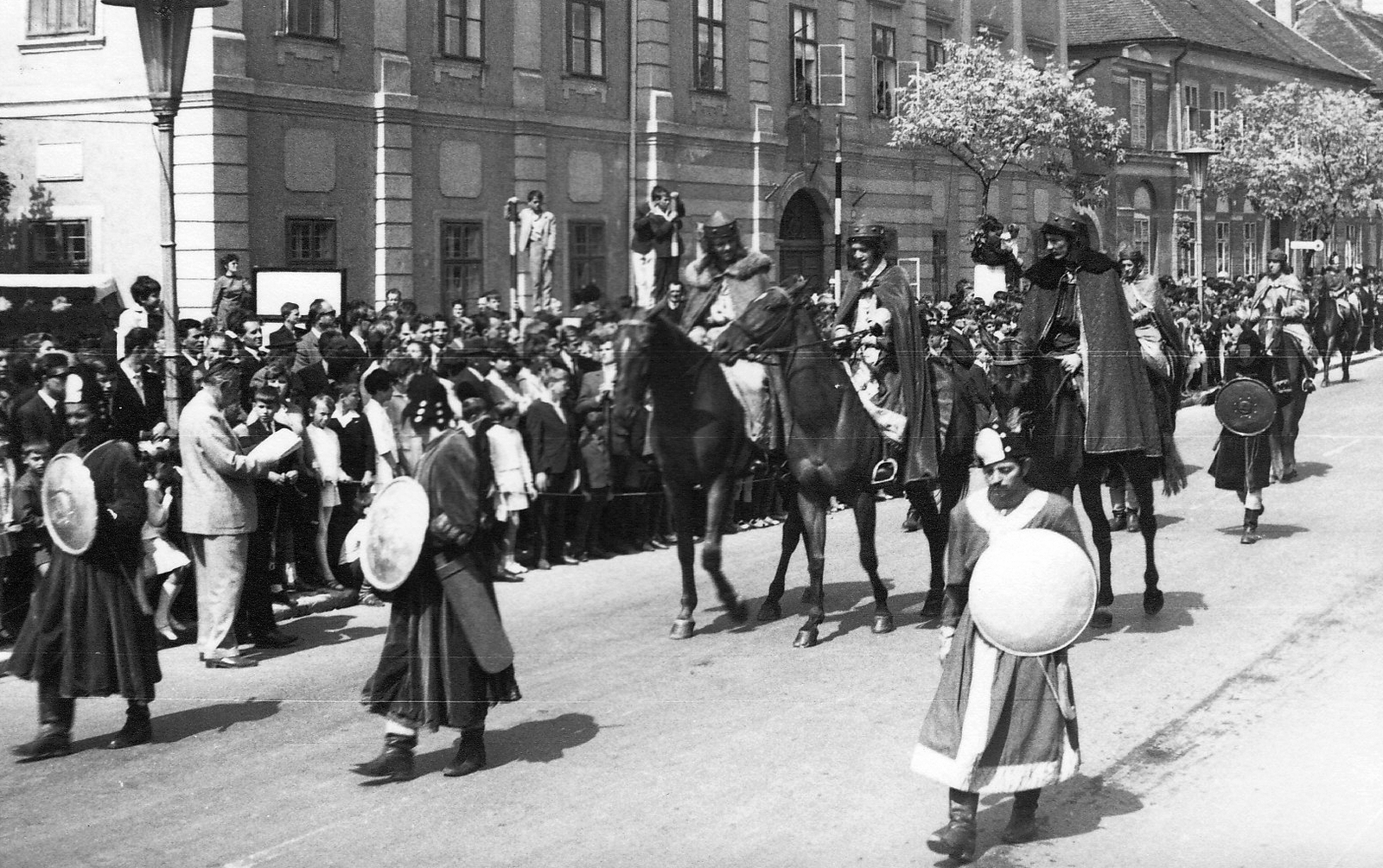 Magyarország, Szombathely, Szily János (Alkotmány) utca, a Savaria Történelmi Karnevál résztvevőinek felvonulása. Háttérben a Mindszenty József (Templom) tér sarkán a Savaria Gimnázium és Középiskolai Leánykollégium (később Egyházmegyei Könyvtár és a Brenner János Kollégium) épülete., 1967, Kelemen Zoltán, utcakép, felvonulás, jelmez, közönség, lovas, Fortepan #69947