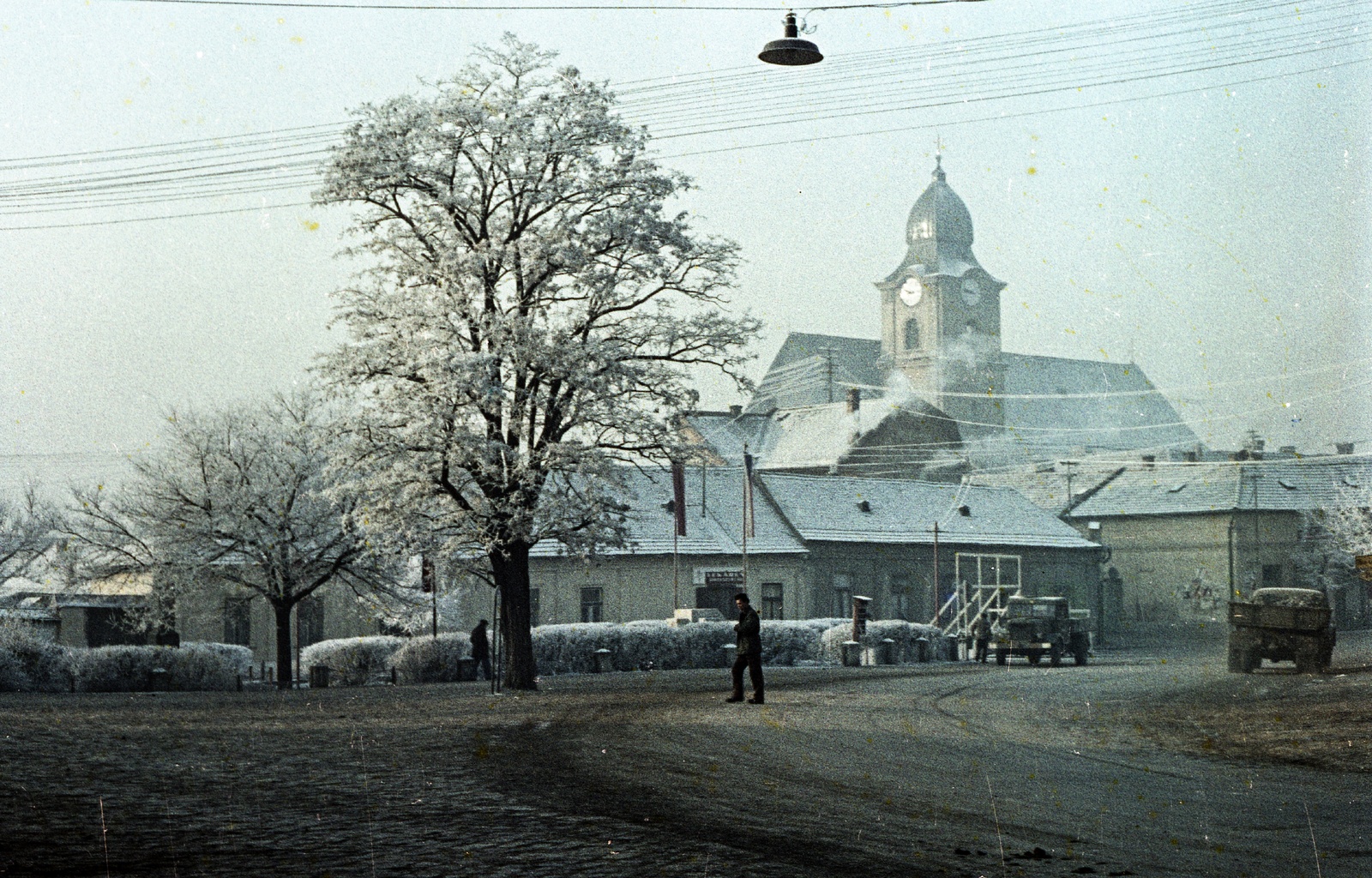Slovakia, Fiľakovo, ulica Slovenského národného povstania (Szlovák Nemzeti Felkelés), szemben a katolikus templom., 1961, Zsanda Zsolt, Vajszada Károly, Czechoslovakia, church, colorful, commercial vehicle, street view, frost, street lamp, Fortepan #70040