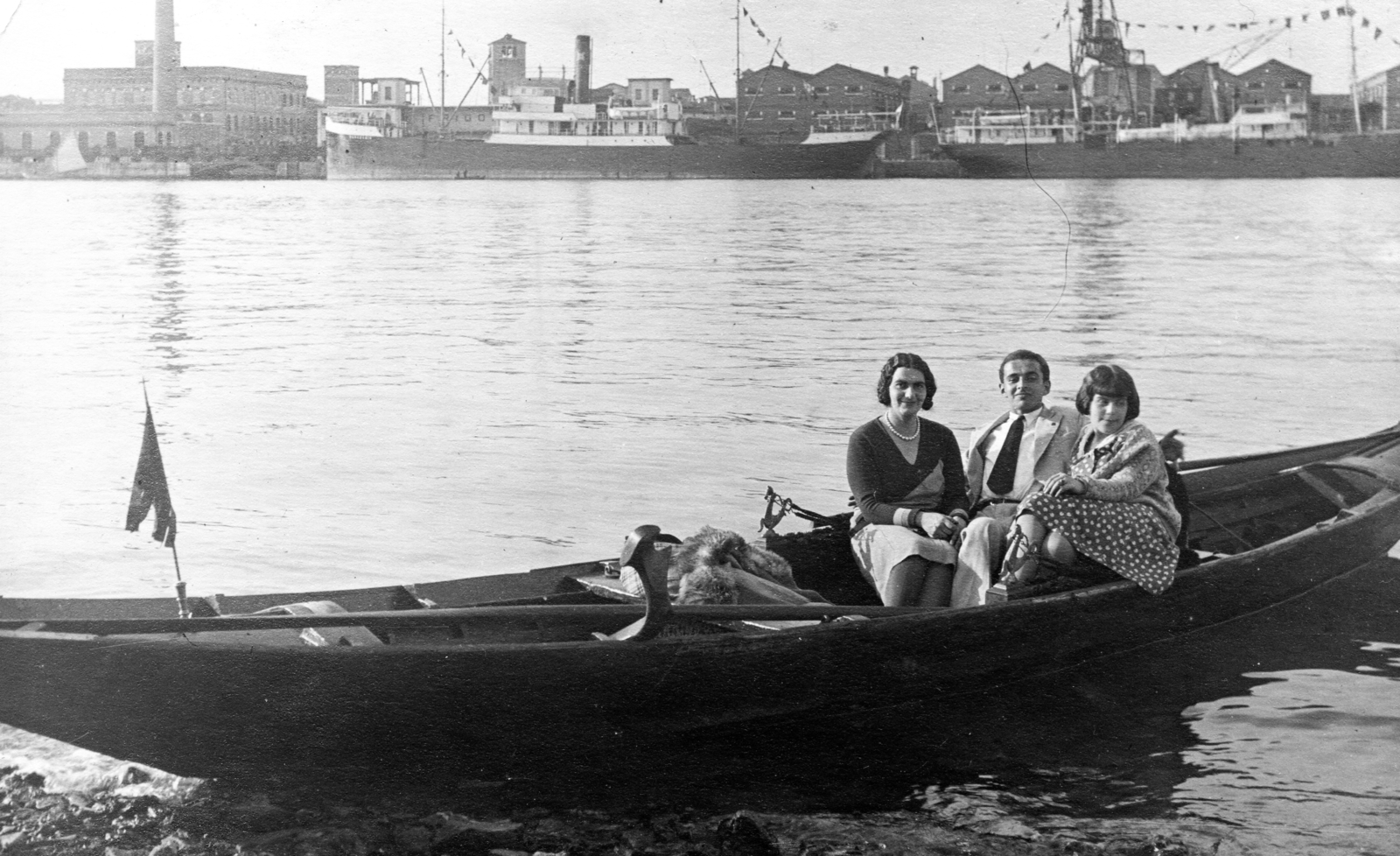 Italy, Venice, Canal della Giudecca a Sacca Fisola szigetről nézve. Szemben a kikötői raktárak ma az egyetemi negyed épületei., 1933, Teodoro Wolf-Ferrari, ship, flag, tableau, women, man, port, rowing boat, Fortepan #70294