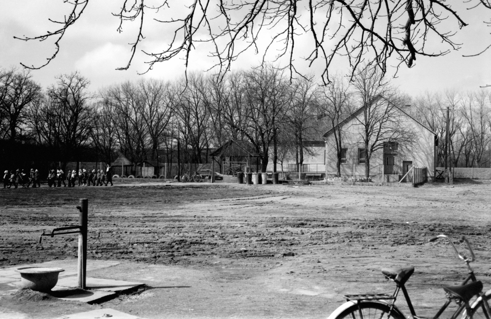 Magyarország, Dunavecse, a Zrínyi utcai Általános Iskola udvara az óvoda felé nézve. Háttérben az árvízvédelmi töltés., 1975, Jáki László, kerékpár, óvoda, gyerekek, közkút, Fortepan #70414