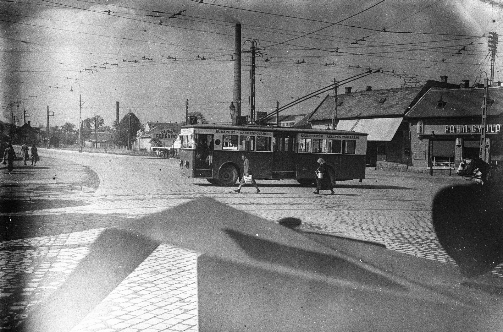 Hungary, Óbuda, Budapest III., az első budapesti trolibuszvonal (Vörösvári út - Óbudai temető) Vörösvári úti végállomása. Balra a Bécsi út., 1934, Lissák Tivadar, trolley bus, cobblestones, factory chimney, Budapest, Fortepan #71049