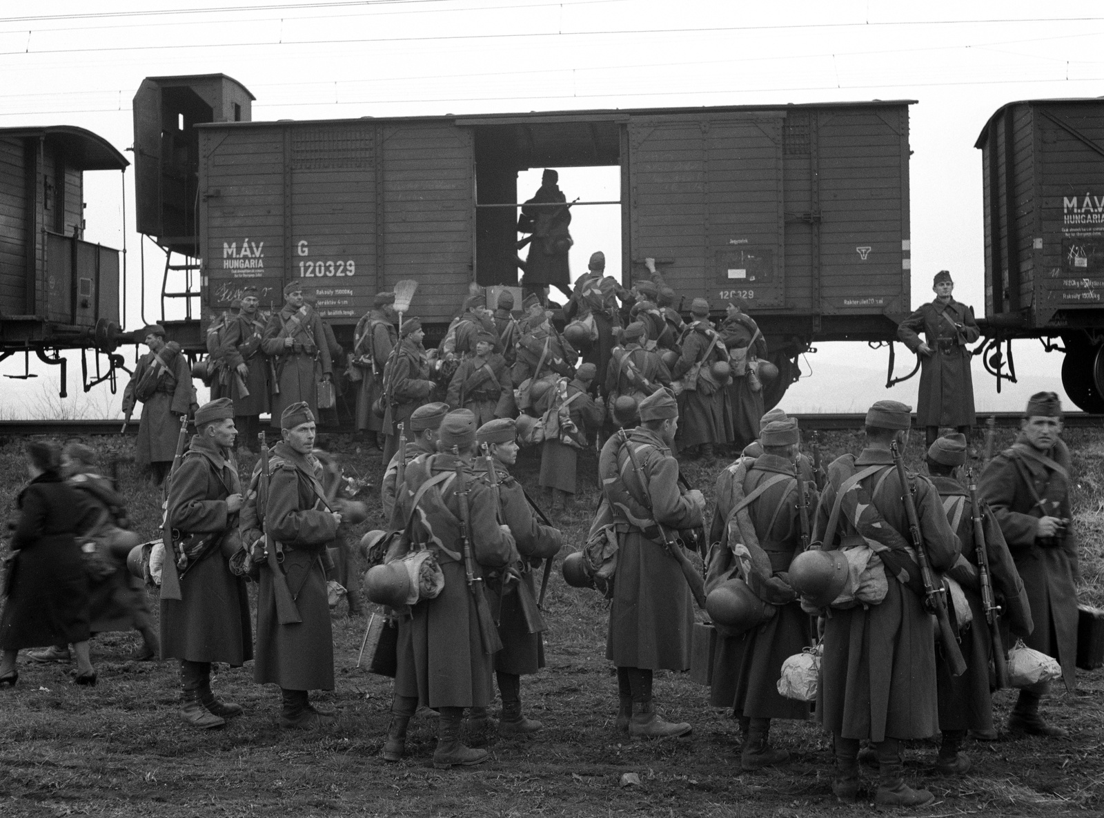 Hungary, Szentendre, bevagonírozás a Görgey Artúr laktanyába vezető vágánynál., 1941, Lissák Tivadar, Hungarian Railways, railway, weapon, soldier, helmet, sword, coach, bag, gun, ground cloth, "Bocskai" side cap, Fortepan #71467