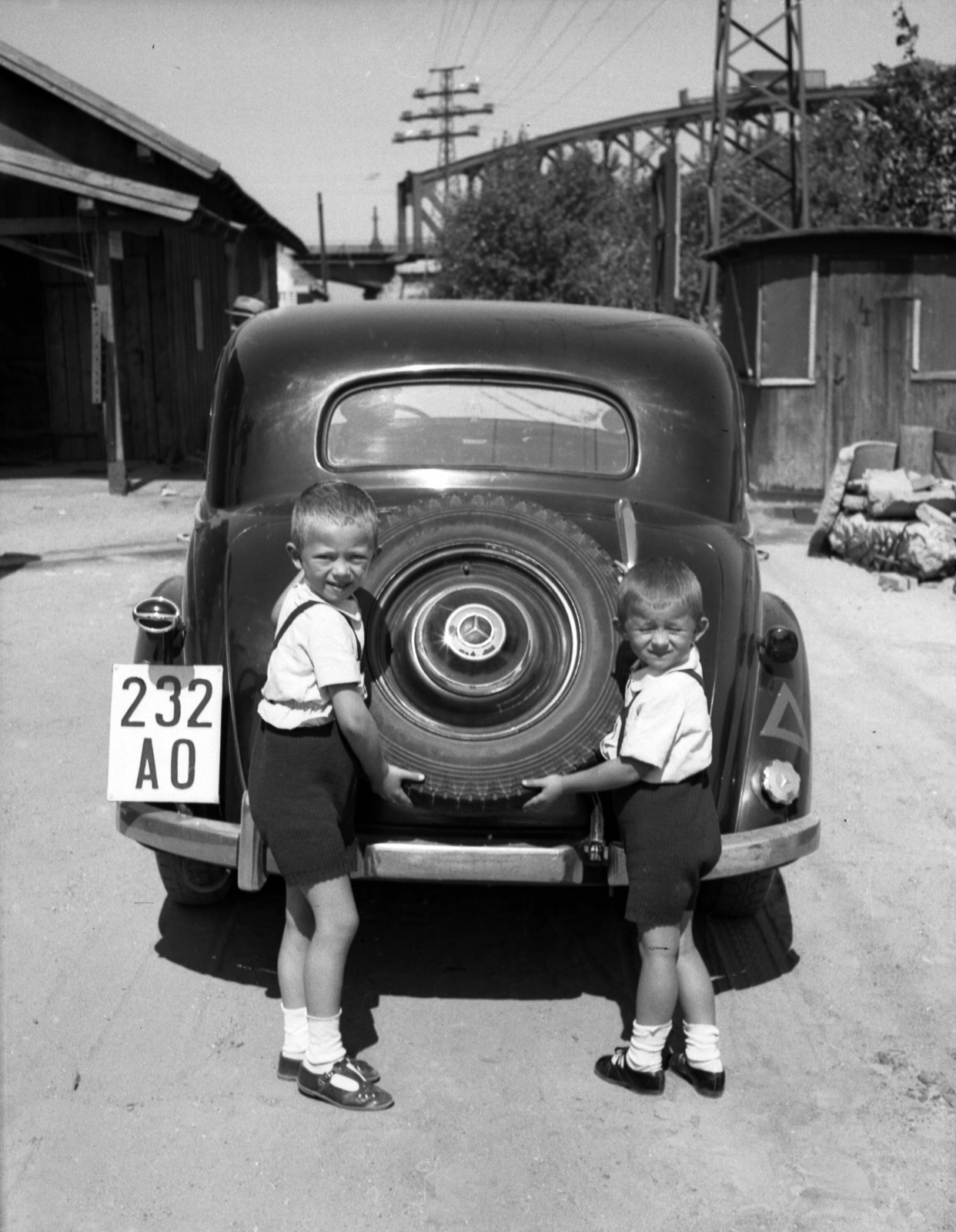 Hungary, Budapest XI., Kopaszi gát, a felvétel a Duna alatti járható kábelalagút építési területén készült, háttérben az Összekötő vasúti híd., 1941, Lissák Tivadar, Gerrman brand, Mercedes-brand, railway bridge, automobile, number plate, spare wheel, Budapest, Fortepan #71660