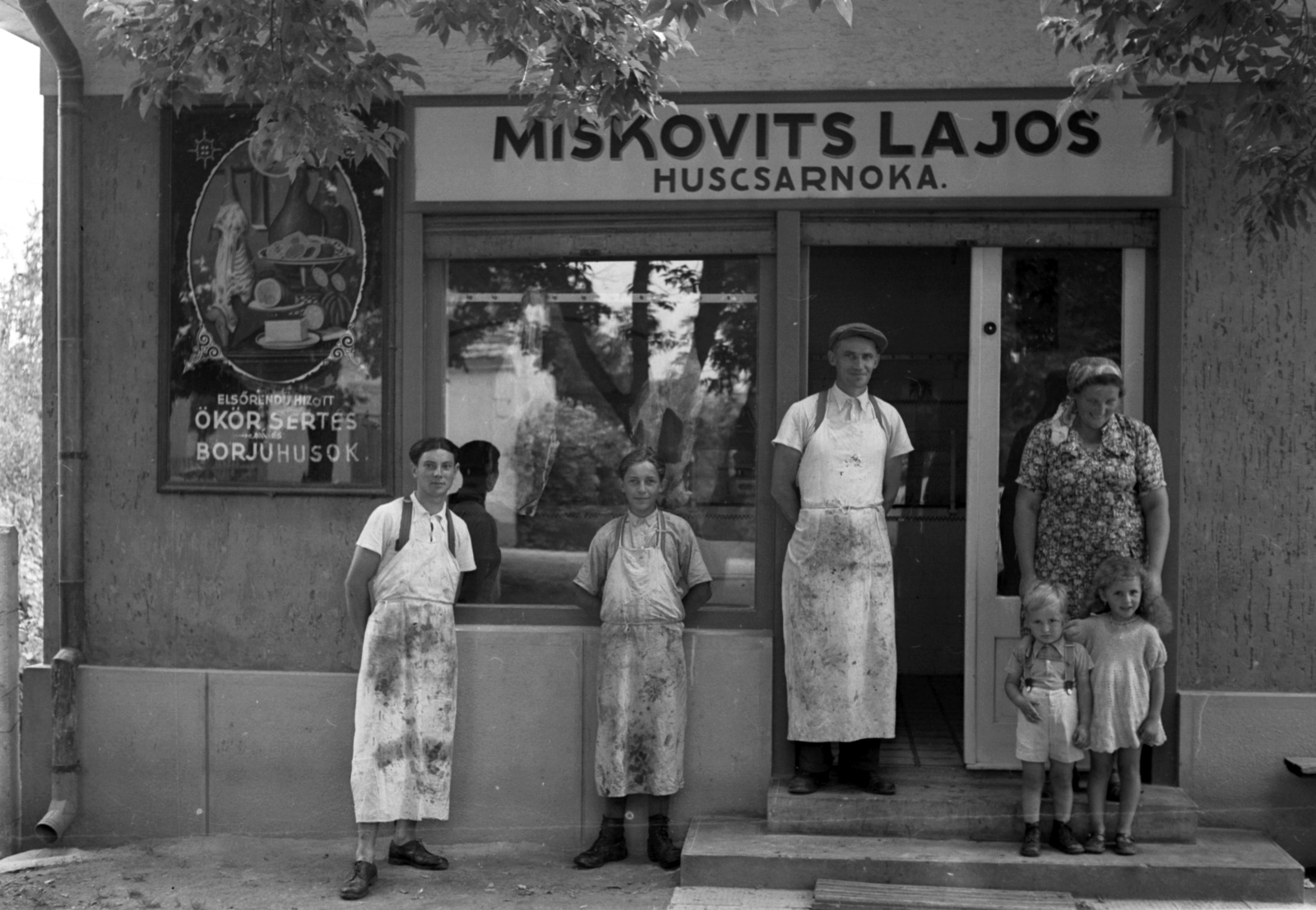 Magyarország, Balatonmáriafürdő, gróf Széchényi Imre tér (Ady Endre utca) 1., az ajtóban Miskovits Lajos az üzlet tulajdonosa., 1942, Lissák Tivadar, cégtábla, csoportkép, hentesüzlet, Best of, üzletportál, ajtóban állás, Fortepan #71857