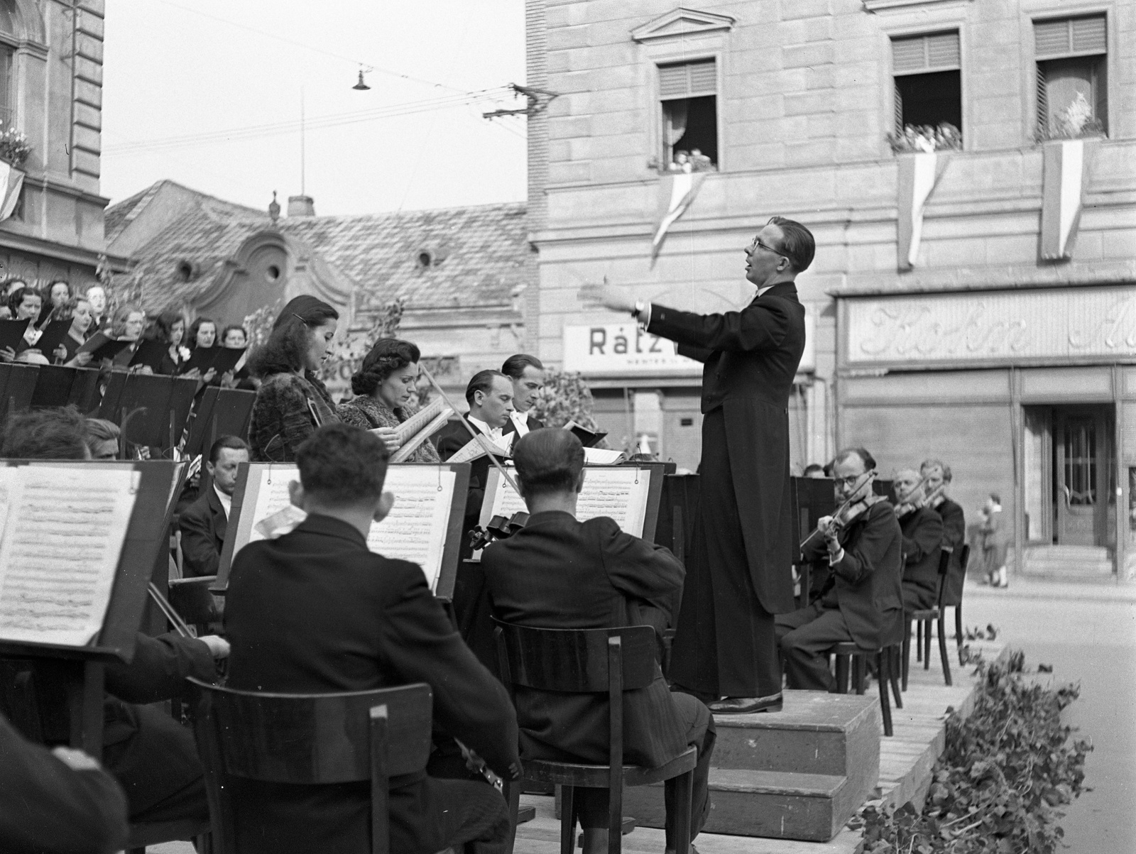 Slovakia, Komarno, Klapka György tér, a Budapesti Kórus és a Székesfővárosi Zenekar hangversenye a Városháza előtt., 1943, Lissák Tivadar, musical instrument, flag, musician, violin, sheet music, music-stand, conductor, Best of, Fortepan #72173