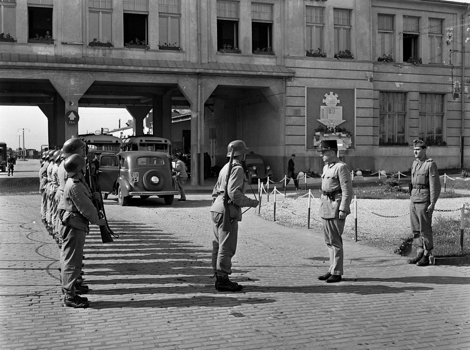 Hungary, Budapest XVI., Mátyásföld, Újszász utca 41-43. (Keresztúri út 1-3.), Magyar Királyi Honvéd gépkocsiszertár, jelentéstétel., 1943, Lissák Tivadar, bus, military, weapon, helmet, soldier, salute, automobile, gun, Budapest, Fortepan #72298