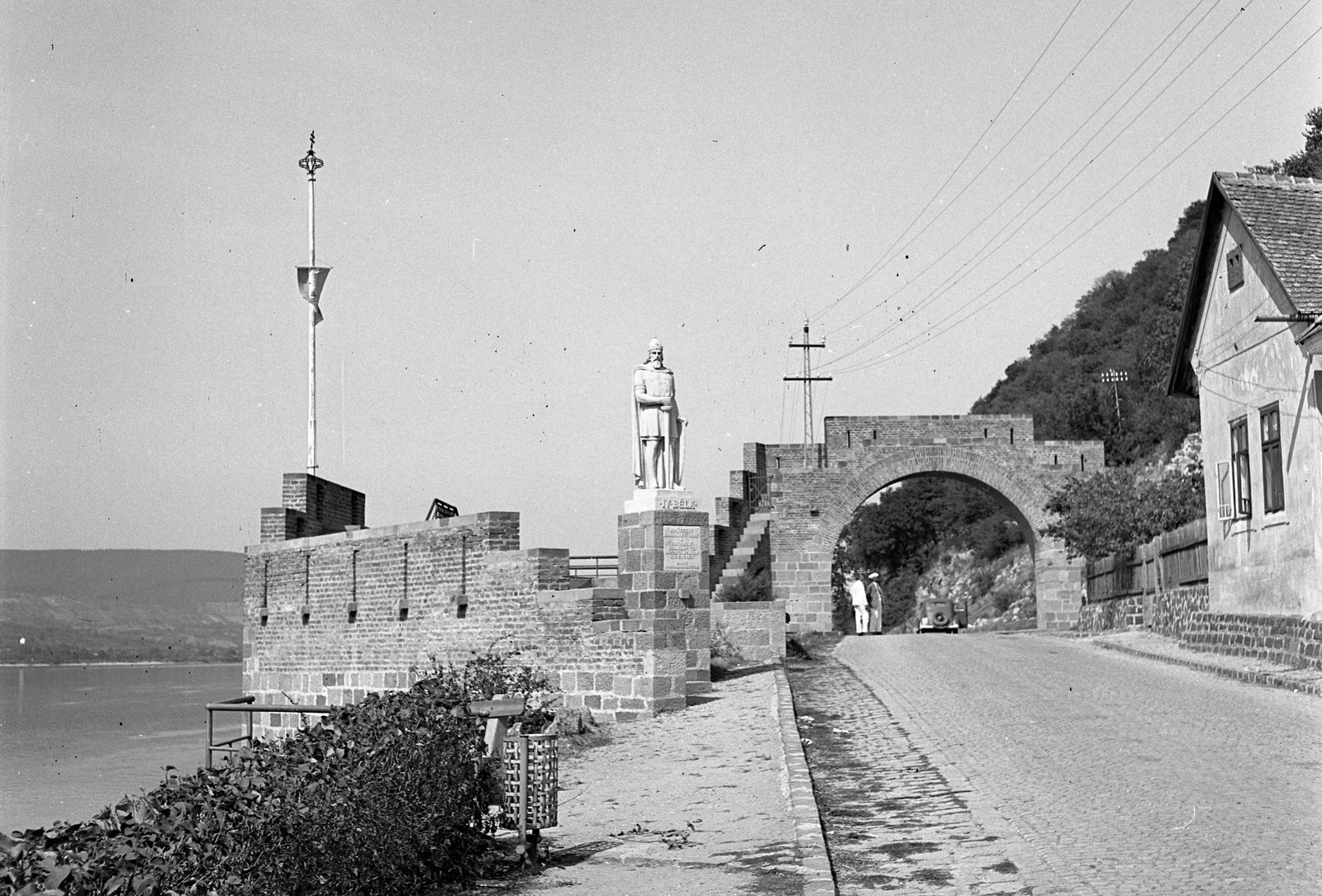 Hungary,Danube Bend, Visegrád, Vizibástya az országzászlóval és a Városkapu, előtérben IV. Béla szobra (Krasznai Lajos, 1939.). , 1943, Lissák Tivadar, flag, gate, sculpture, tower, flag pole, Béla IV of Hungary-portrayal, Fortepan #72461