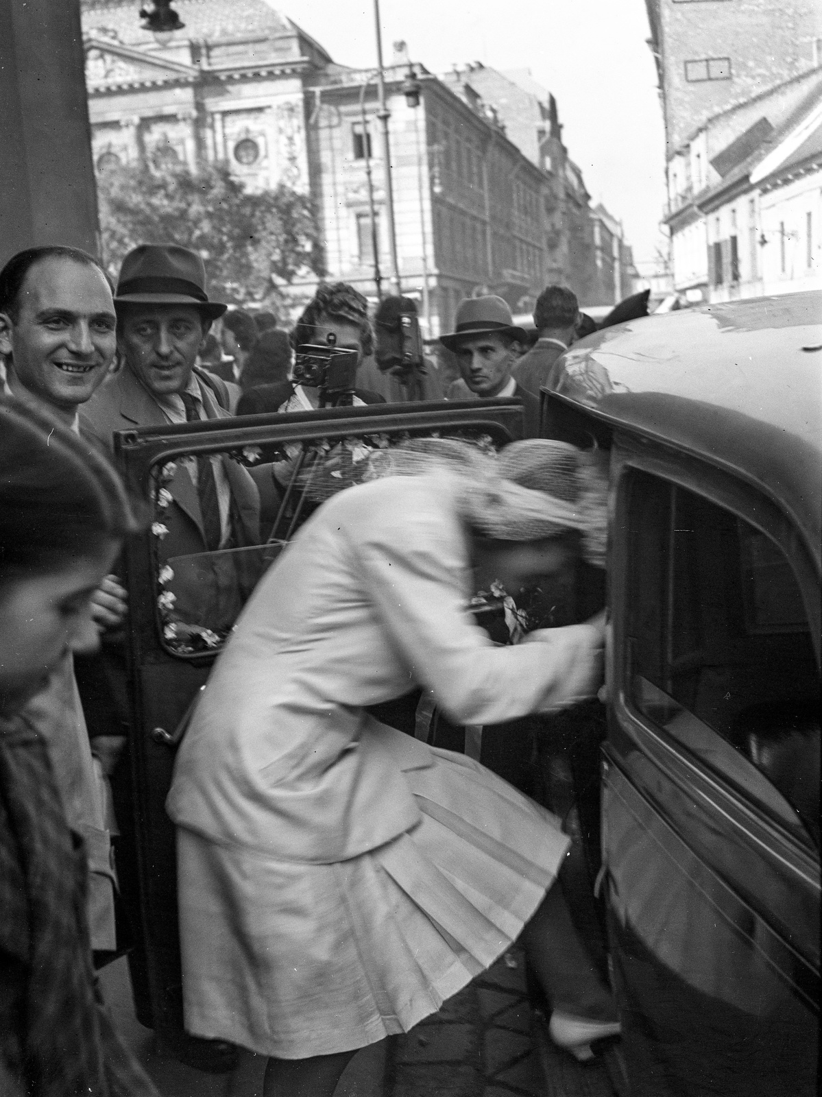 Hungary, Budapest I., Fő utca a Kapucinus templomnál, háttérben balra a Corvin téren a Budai Vigadó., 1943, Lissák Tivadar, wedding ceremony, bride, photography, automobile, Budapest, entering the car, Fortepan #72537