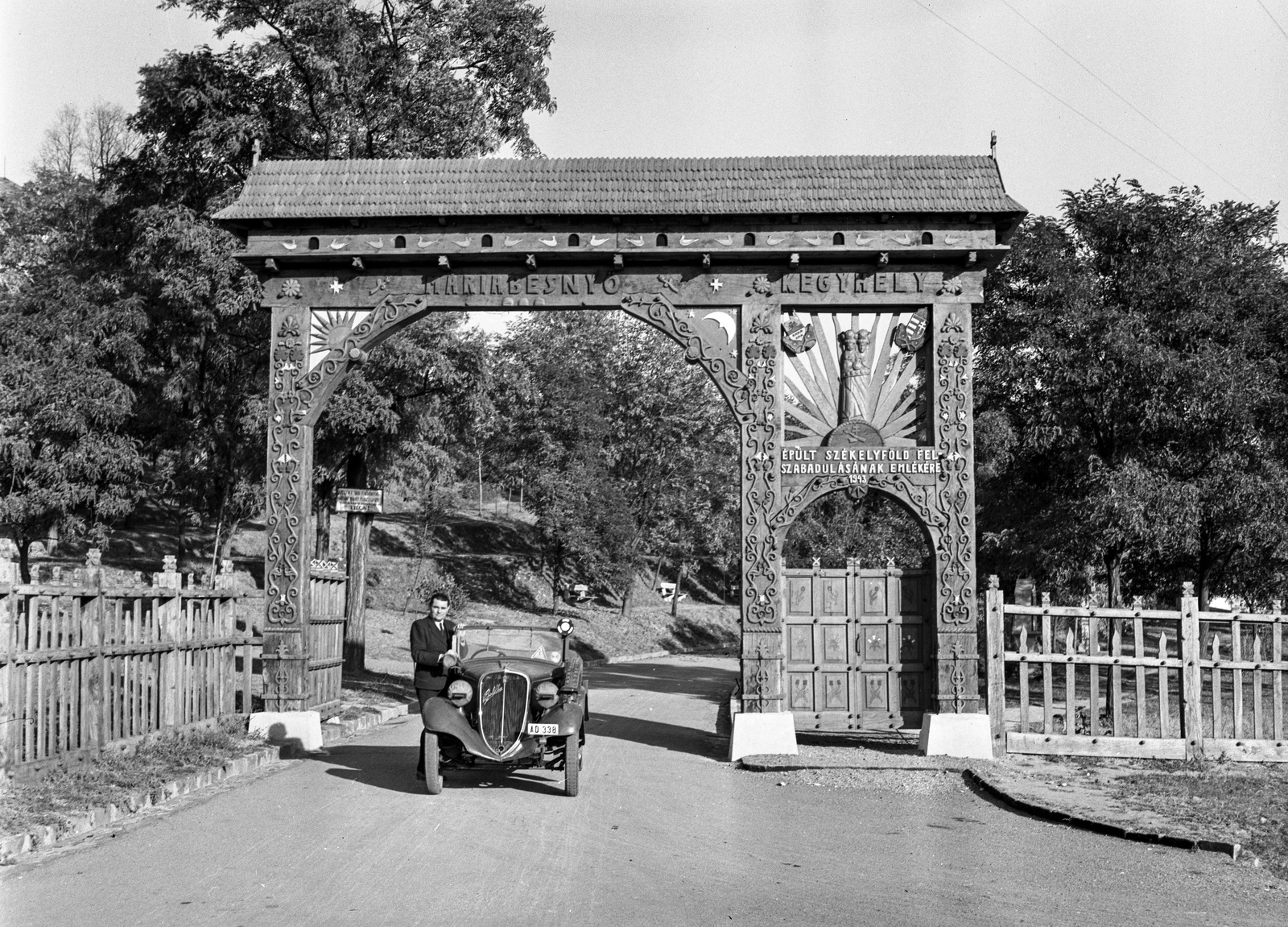 Hungary, Máriabesnyő, Gödöllő, székely kapu a kegyhelyhez vezető úton., 1943, Lissák Tivadar, Fiat-brand, Italian brand, crest, automobile, number plate, sekler gate, woodcarving, Fortepan #72550