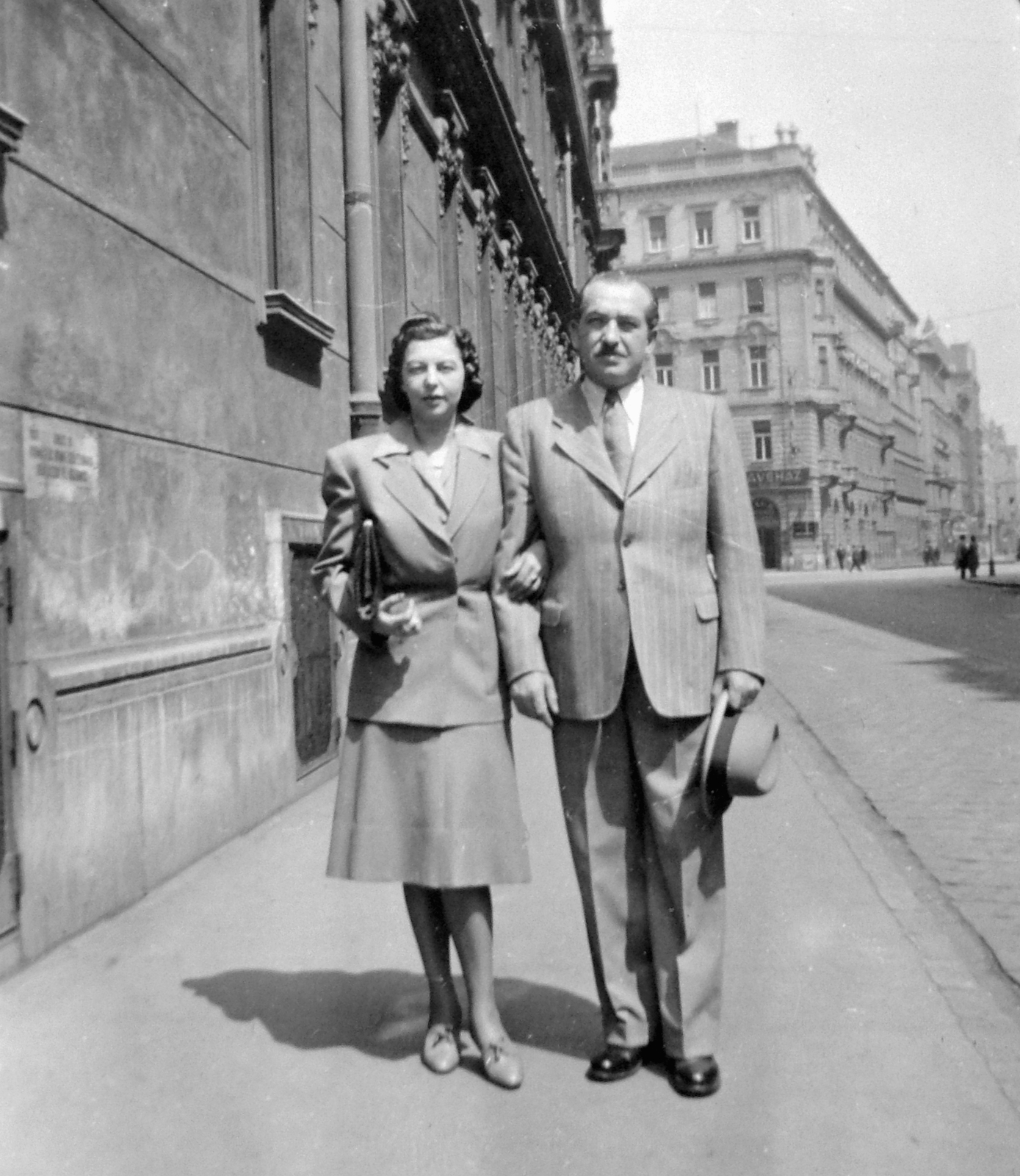 Magyarország, Budapest V., Szemere utca, háttérben a Szent István körút és a Hegedűs Gyula utca., 1943, Fortepan, kalap, utcakép, férfi, emberpár, retikül, kettős portré, hölgy, öltöny, kosztüm, Budapest, kart karba öltve, kalap kézben, Fortepan #7257