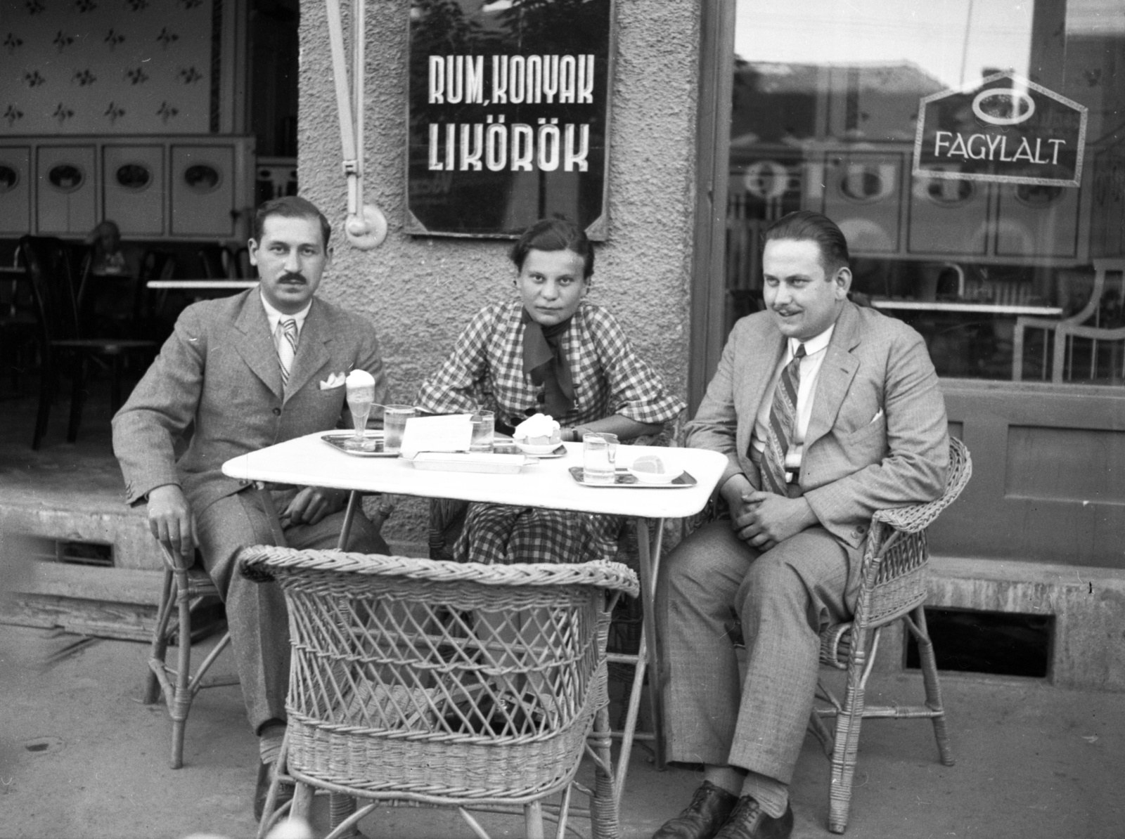 Magyarország, Szolnok, Szapáry utca 28. (ekkor gróf Szapáry utca 1.), Kádár cukrászda., 1935, Lissák Tivadar, vendéglátás, cégtábla, fonott szék, fagylalt, cukrászda, kézműipar, üzletportál, sütemény, üzletbelső, hárman, Fortepan #73130