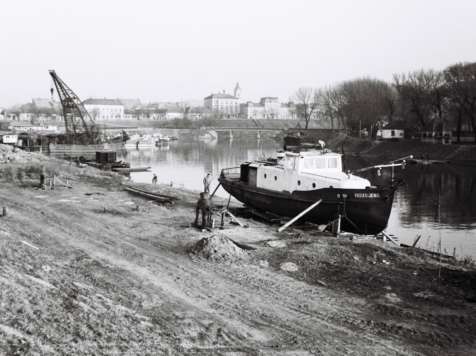 Magyarország, Baja, Sugovica (Kamarás-Duna) partja, szemben az 1982-ben felrobbantott szigeti híd, jobbra a Petőfi-sziget. A háttérben a Páduai Szent Antal-templom tornya., 1963, Márton Gábor, hajó, daru, úszódaru, Vadas Jenő hajó, Fortepan #73624