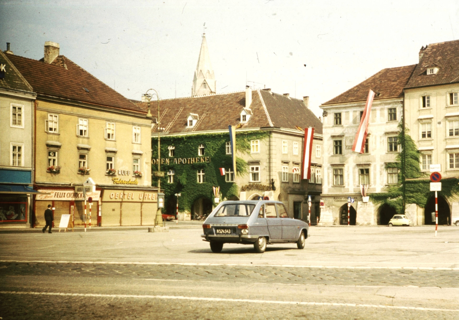 Austria, Wiener Neustadt, Hauptplatz., 1972, Romák Éva, colorful, flag, sign-board, square, street view, Renault-brand, French brand, pharmacy, automobile, number plate, country code sign, Fortepan #73801