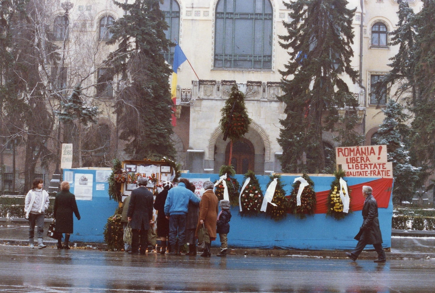Románia,Erdély, Marosvásárhely, Gyözelem tér (Piața Victoriei), egykor Deák Ferenc tér, háttérben a Városháza. Romániai forradalom., 1990, Várhelyi Iván, színes, zászló, utcakép, szecesszió, középület, Komor Marcell-terv, Art Nouveau, Jakab Dezső-terv, román forradalom, rendszerváltás, koszorú, emlékfal, Fortepan #74150