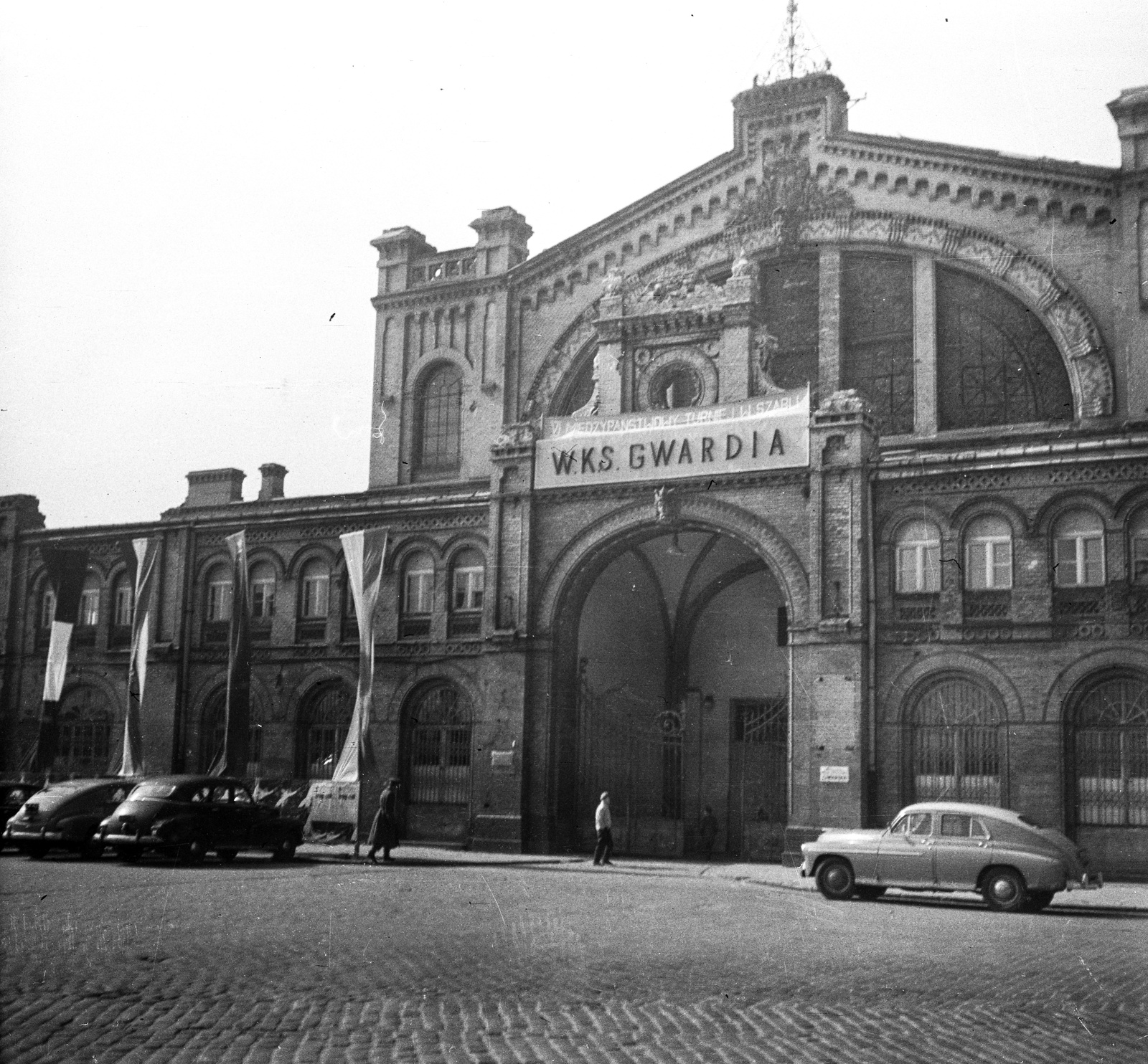 Poland, Warsaw, plac Mirowski, sportcsarnok, ma Hale Mirowskie vásárcsarnok., 1960, Romák Éva, flag, cobblestones, automobile, market hall, Bolesław Milkowski-design, Ludwik Panczakiewicz-terv, Apoloniusz Nieniewski-design, Władysław Kozłowski-design, Fortepan #75037