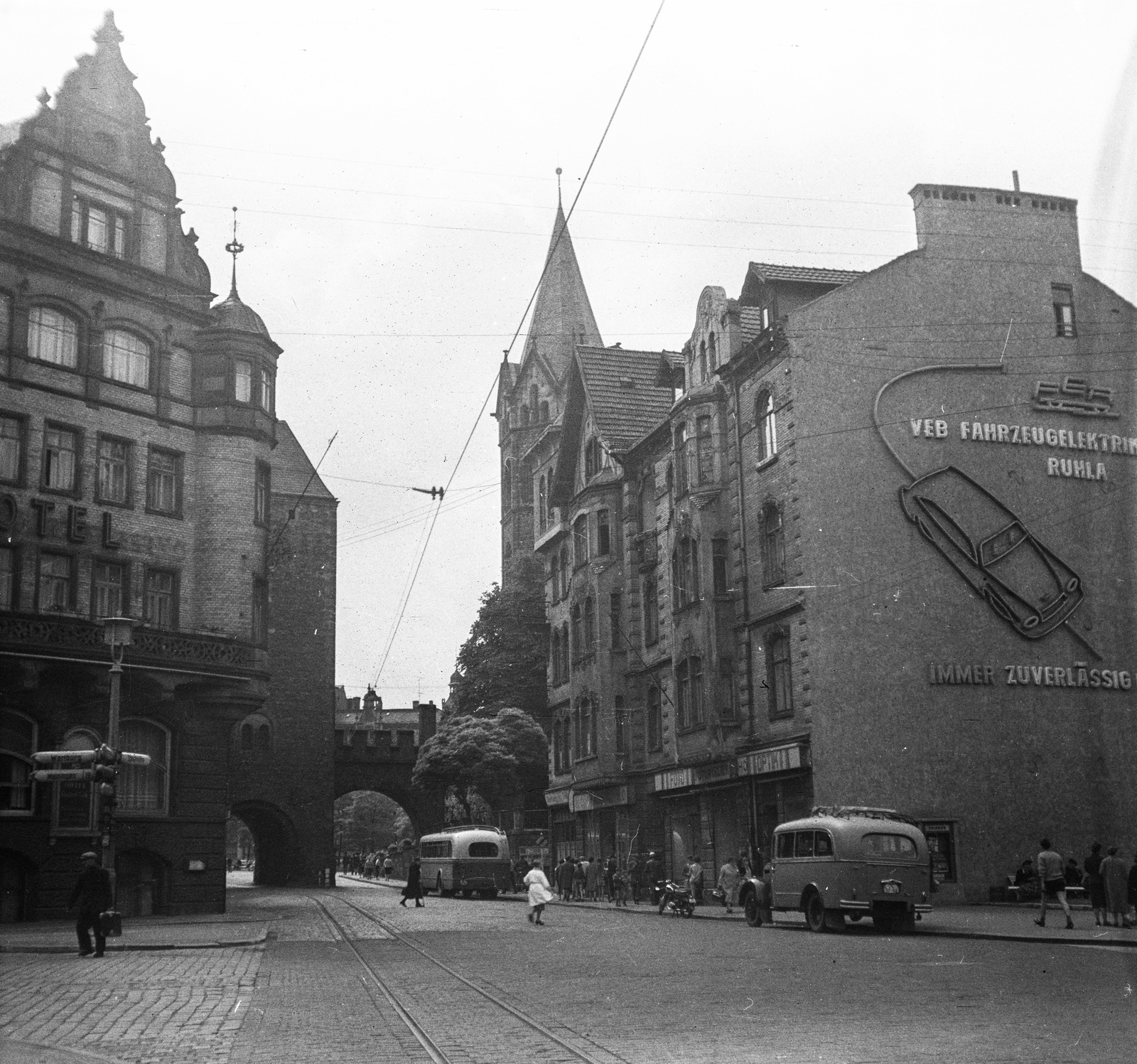 Germany, Eisenach, Bahnhofstrasse, szemben a Nikolaitor, ettől jobbra a Nikolaikirche tornya. A kapun túl a Karlsplatz., 1960, Romák Éva, ad, bus, motorcycle, street view, genre painting, GDR, lamp post, Fortepan #75076