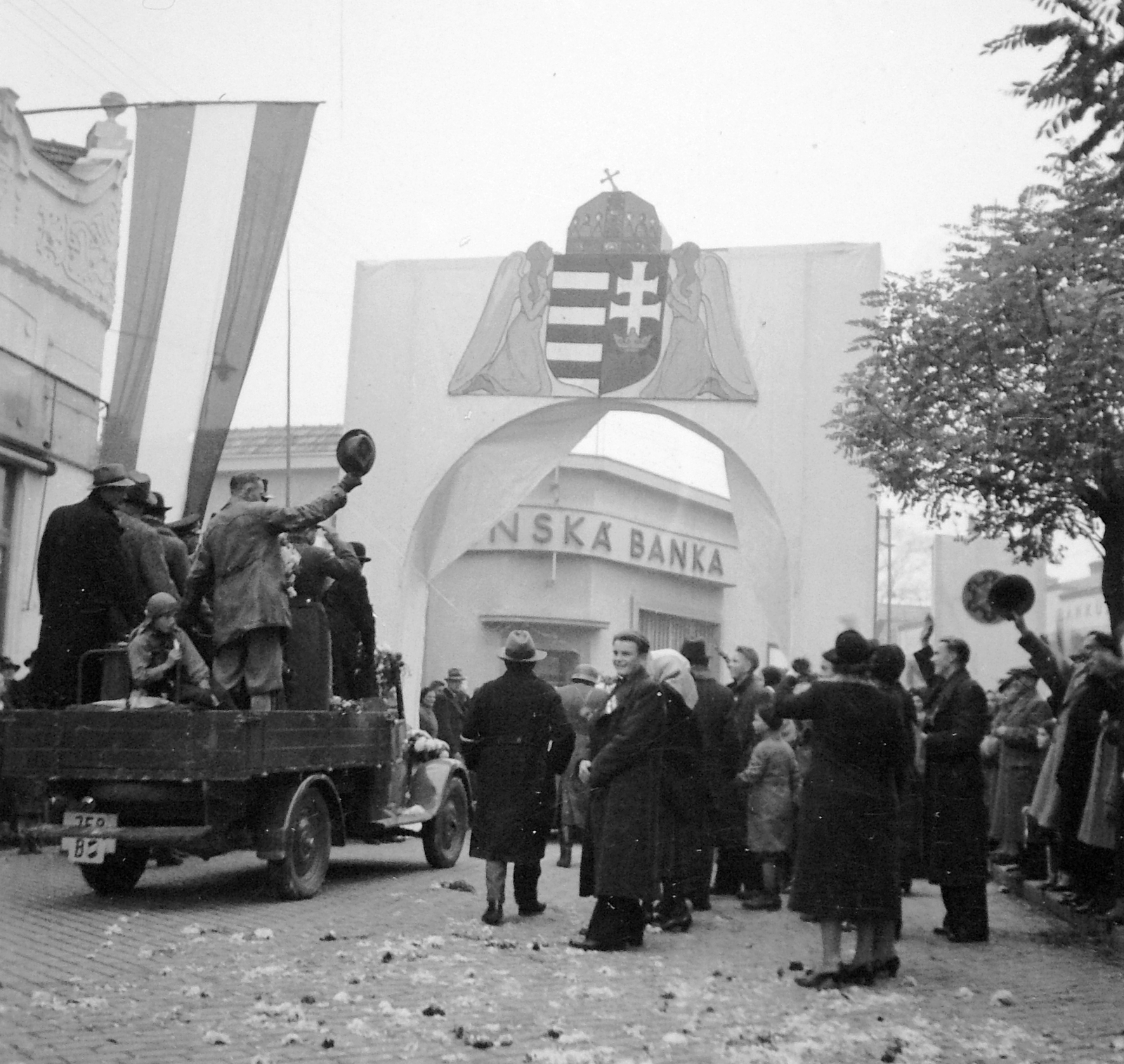Slovakia, Nové Zámky, Milan Rastislav Štefánik (ekkor Széchenyi) utca a Törökszalasztó utca (Turecká ulica) felé nézve, a magyar csapatok bevonulása idején., 1938, Fortepan, territorial gain, flag, commercial vehicle, festive, crest, triumphal arc, national emblem, Fortepan #7521